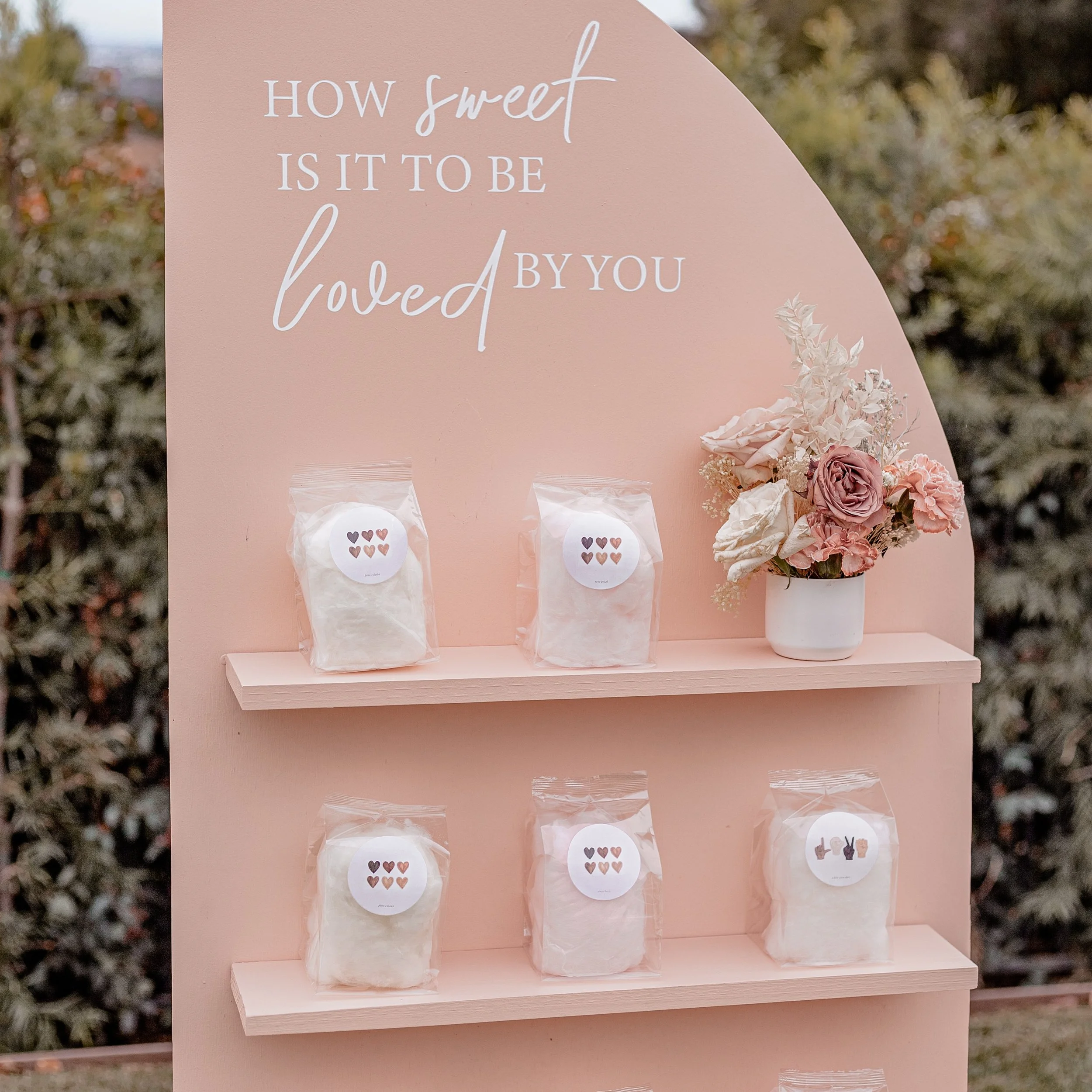 Personalized cotton candy favors displayed on a treat wall for Valentine's day