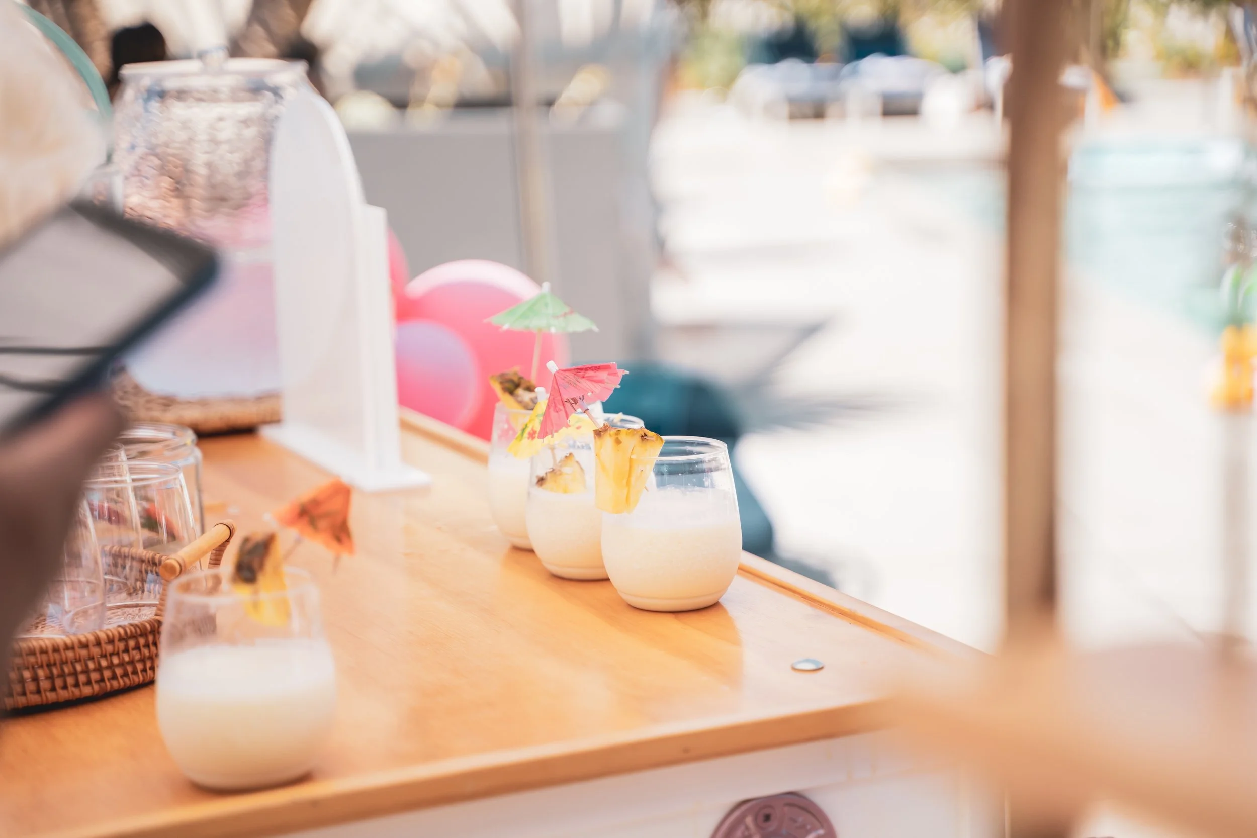 pina colada slushies in disposable tumblers on a wood table