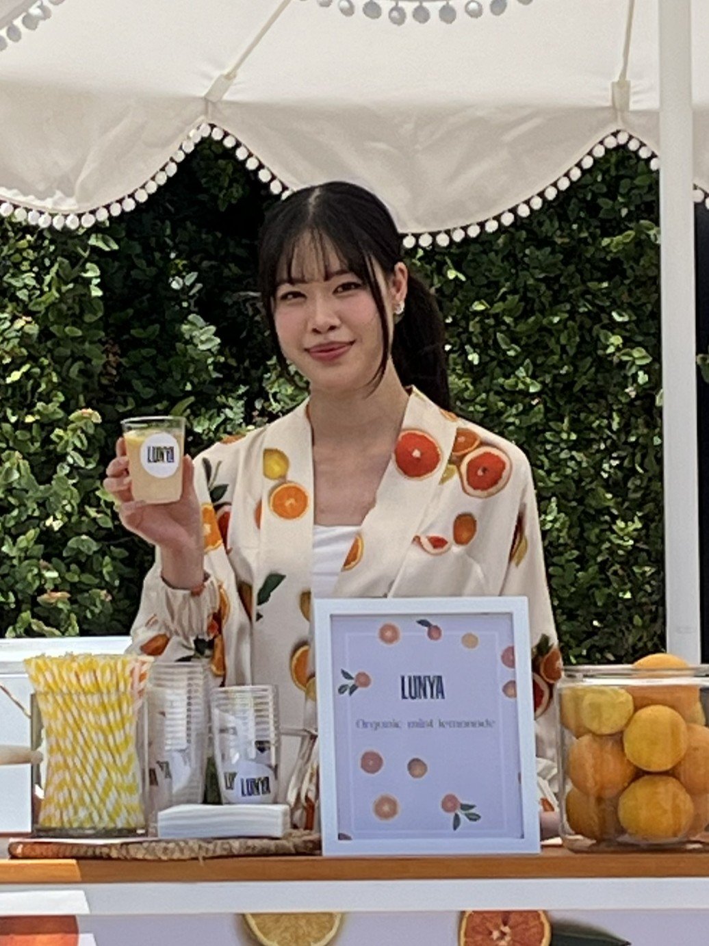 a server dressed in lunya loungewear serving lemonade and smiling