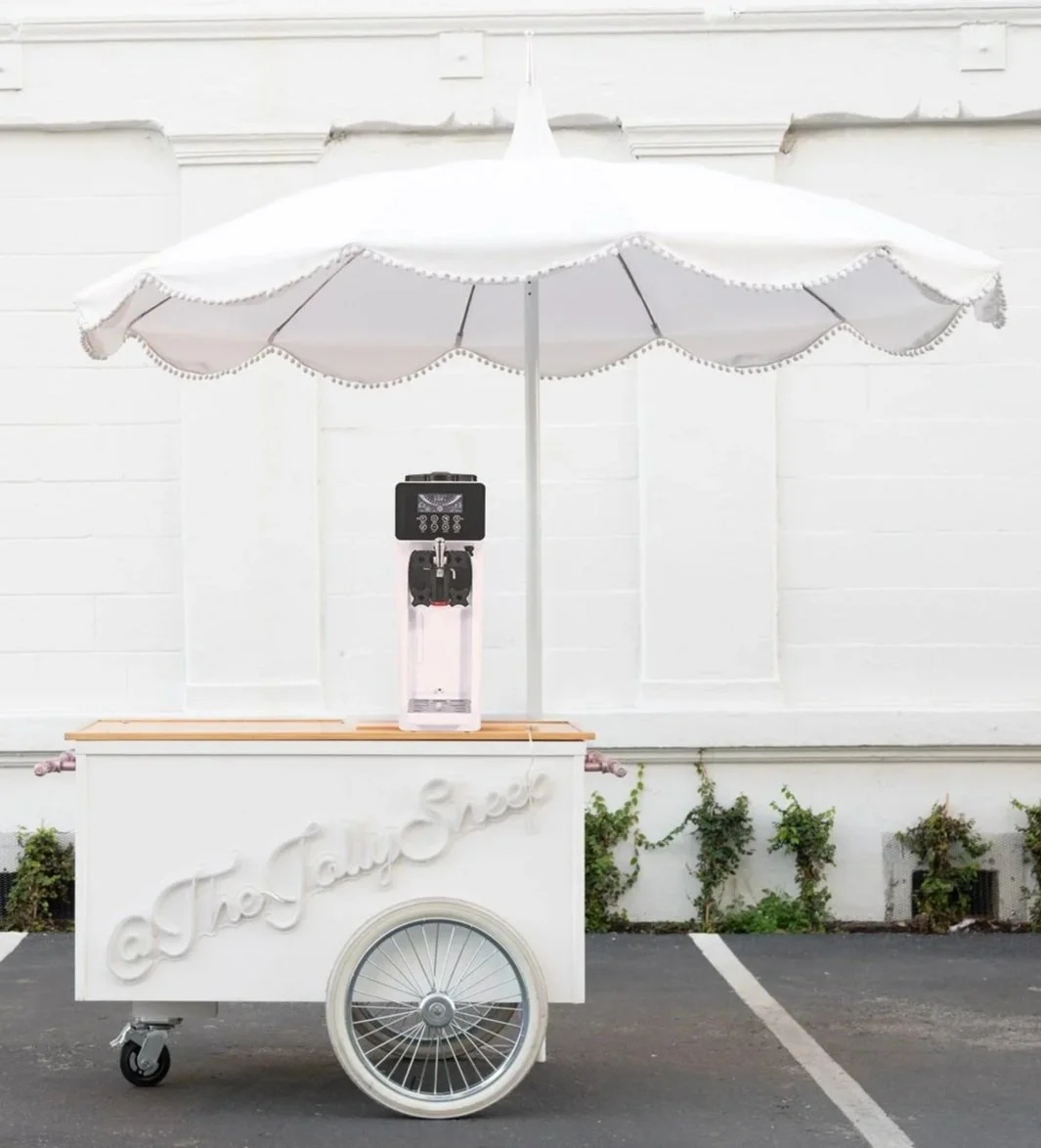 A soft serve machine on a cart with umbrella