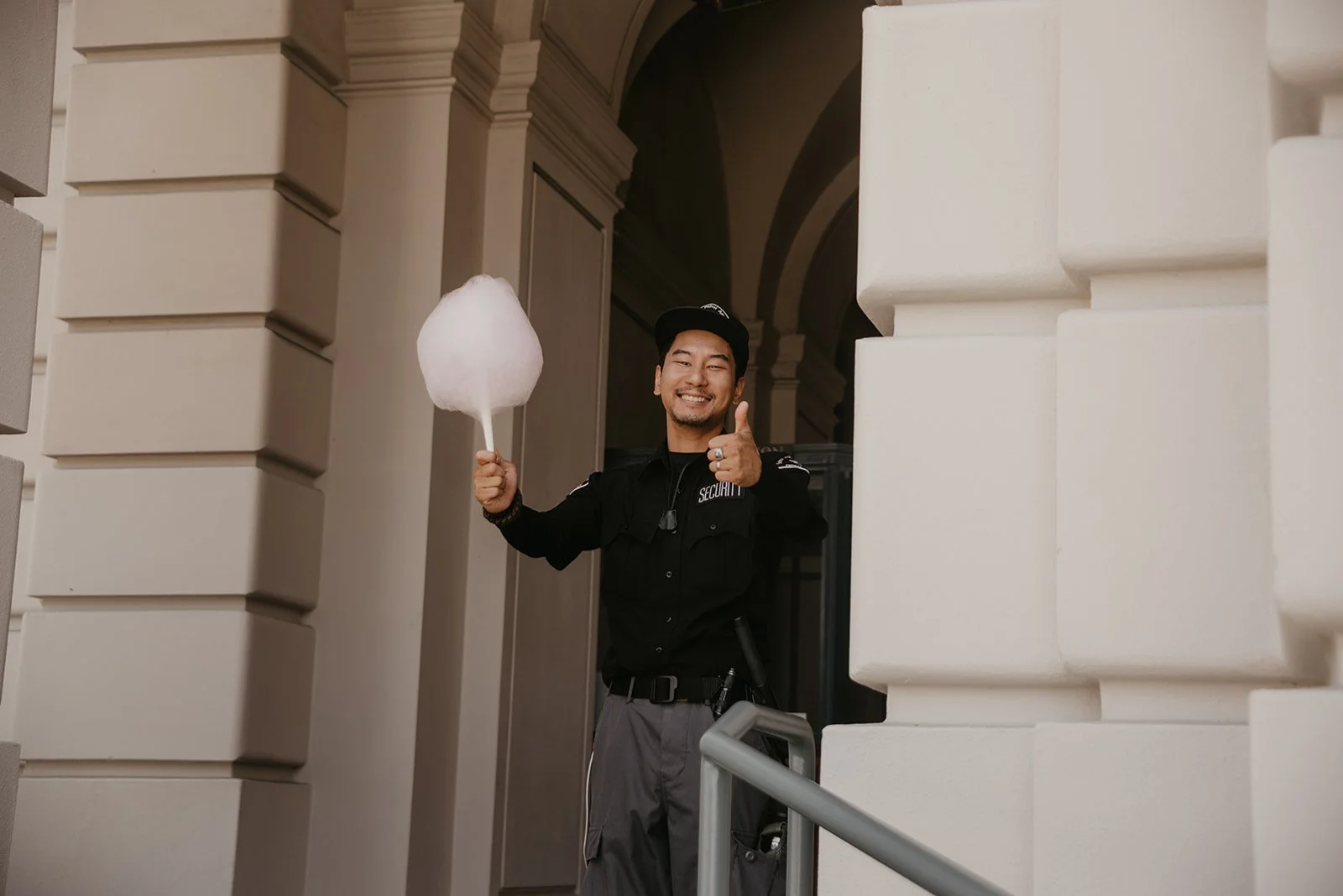 a security guard giving a thumbs up and smiling after receiving a cotton candy