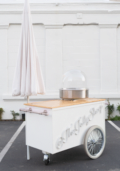 an animated gif of a catering cart with the umbrella and countertop changing into various colors