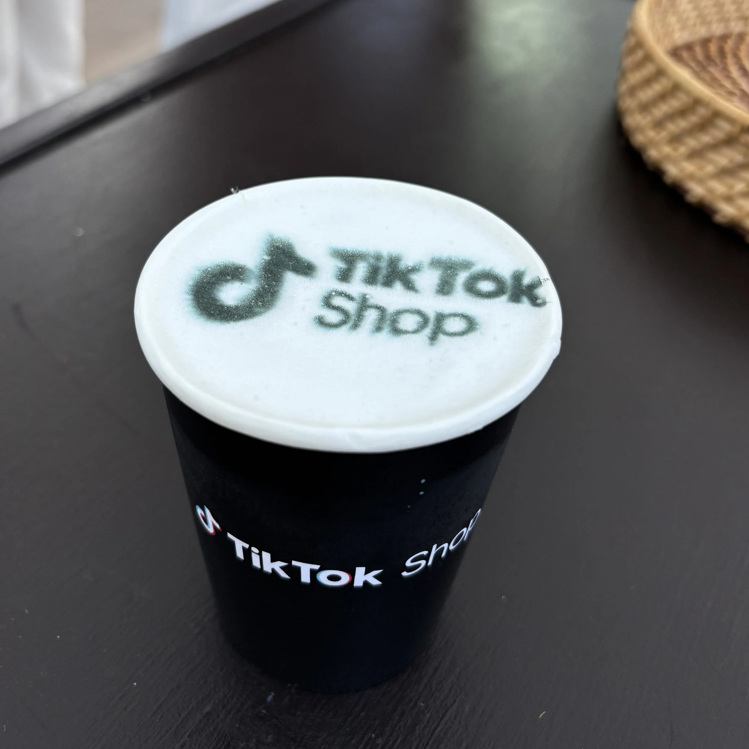 A cup of hot chocolate with a tiktok shop logo on the foam top