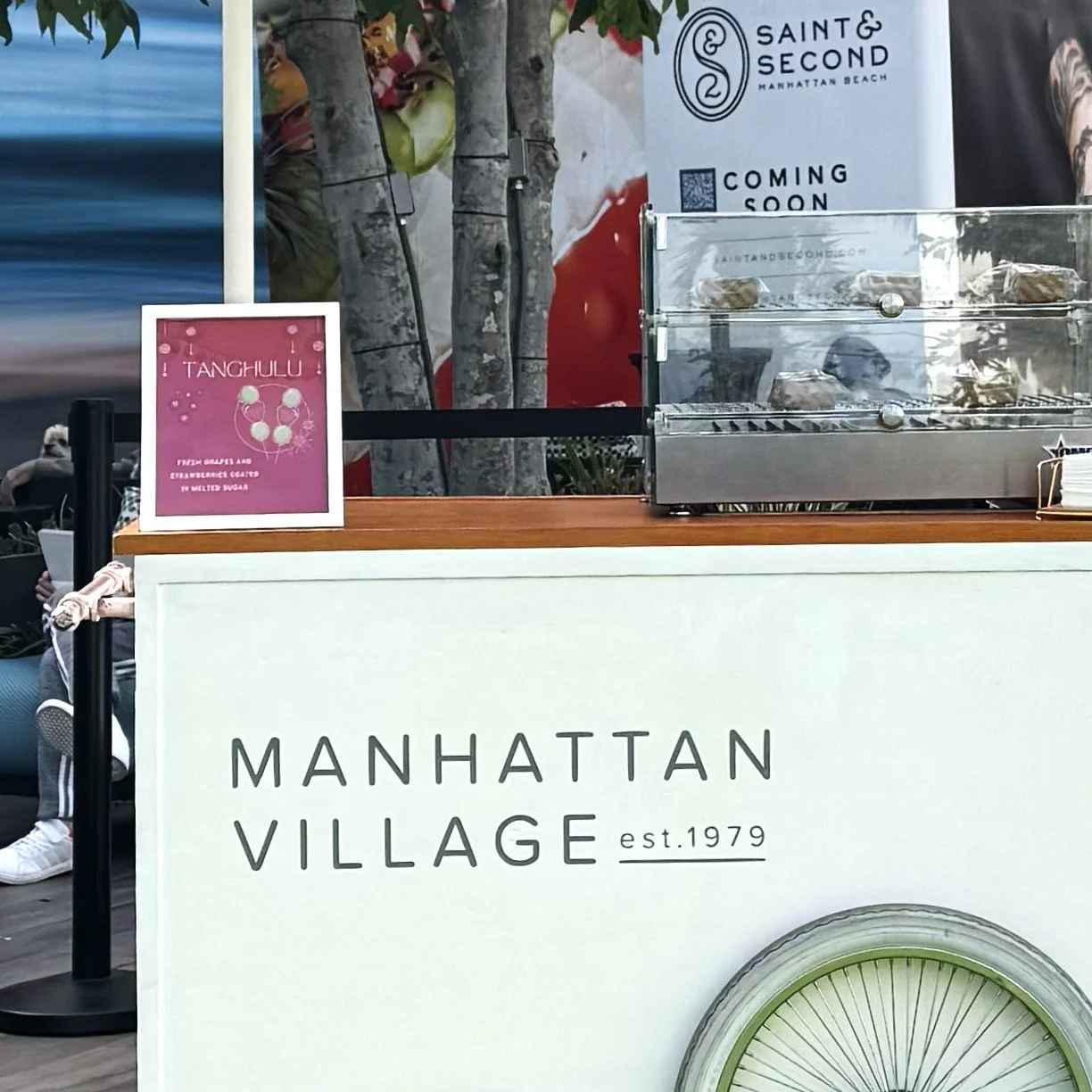 A cart with the manhattan beach village decal and a menu showing tanghulu on offer