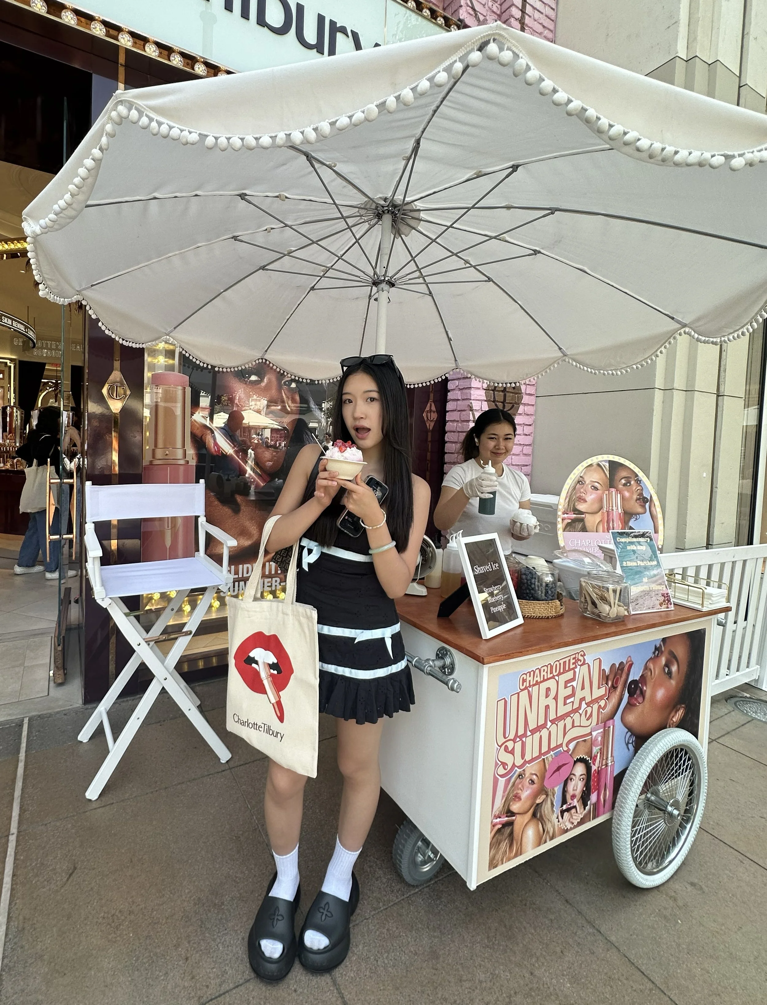 a customer at the jolly sheep shaved ice cart in front of a charlotte tilbury store for a brand activation