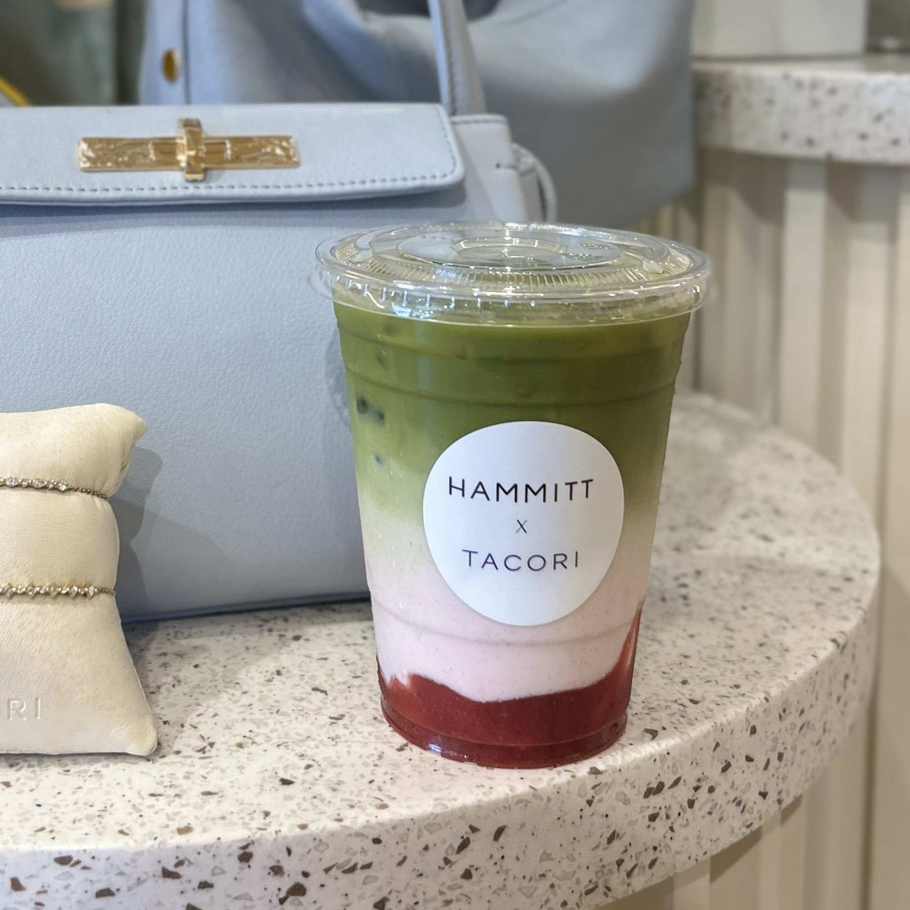 A close up of a matcha cup with a custom label for a Hammitt x Tacori brand activation