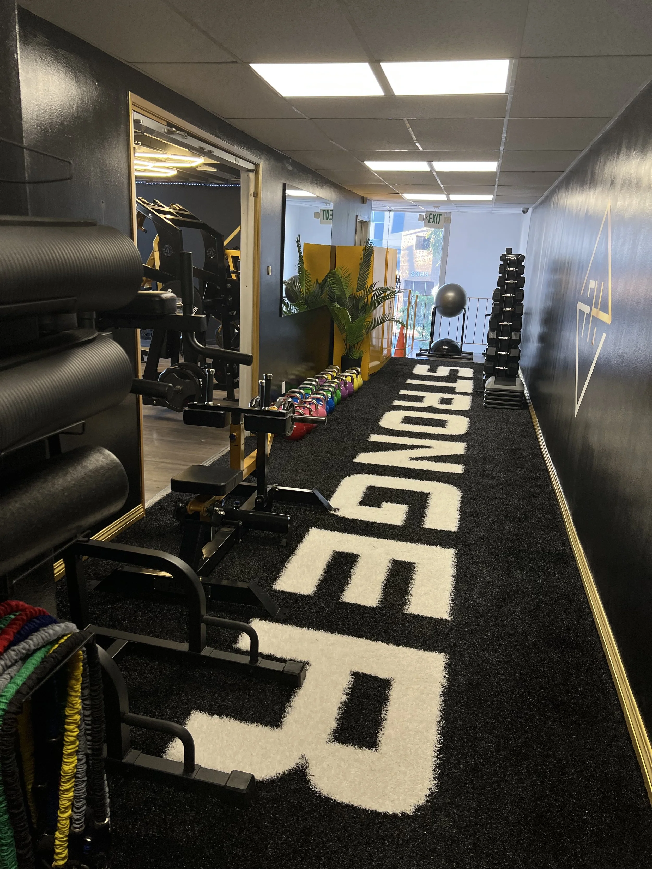 The Functional Training corridor at FulHaus Club leads into our private strength training facility in West Hollywood. Equipped with kettlebells, mobility tools, and functional training stations, this space prepares members for small-group strength se