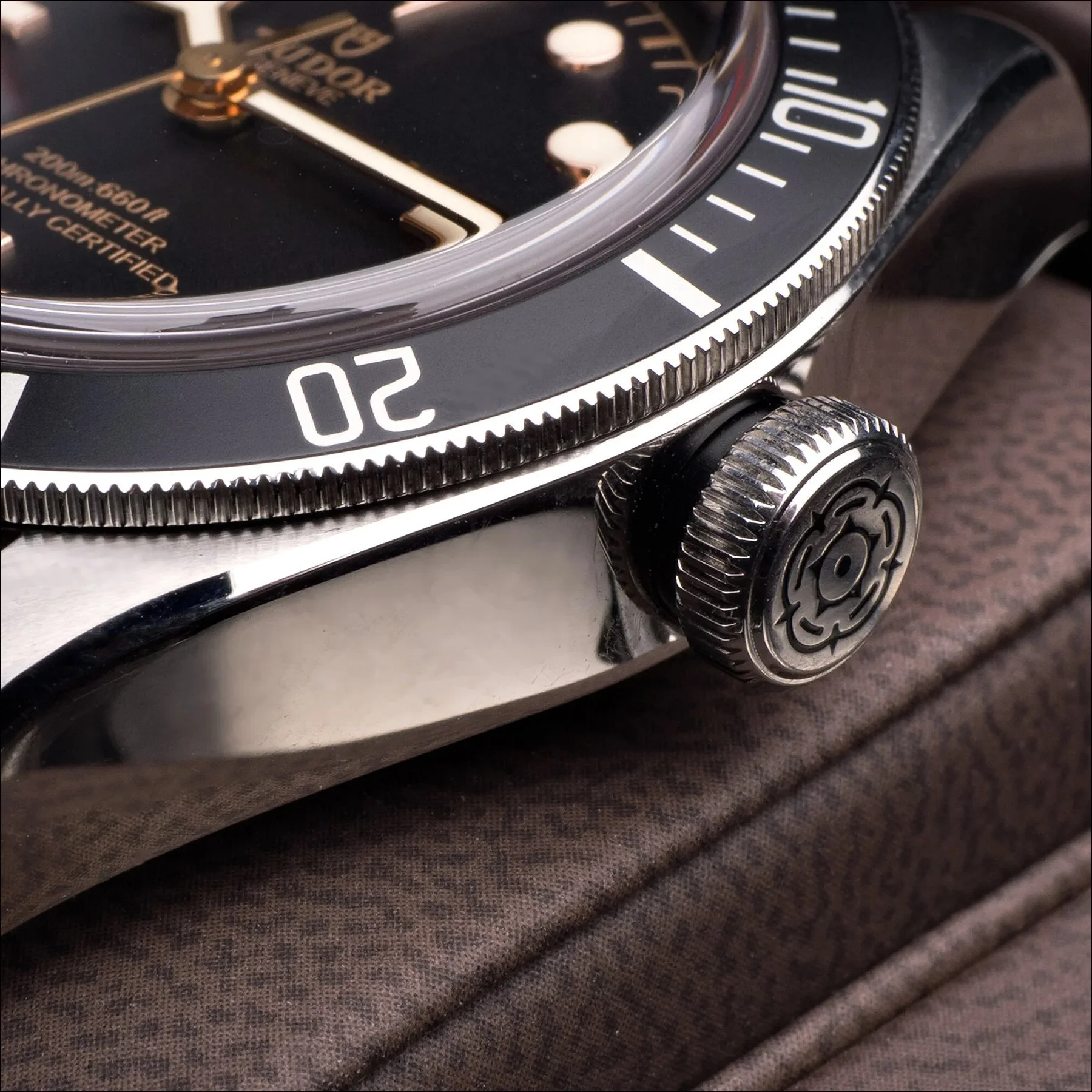 Close-up of a watch bezel and crown showing minute markers and mechanical details.