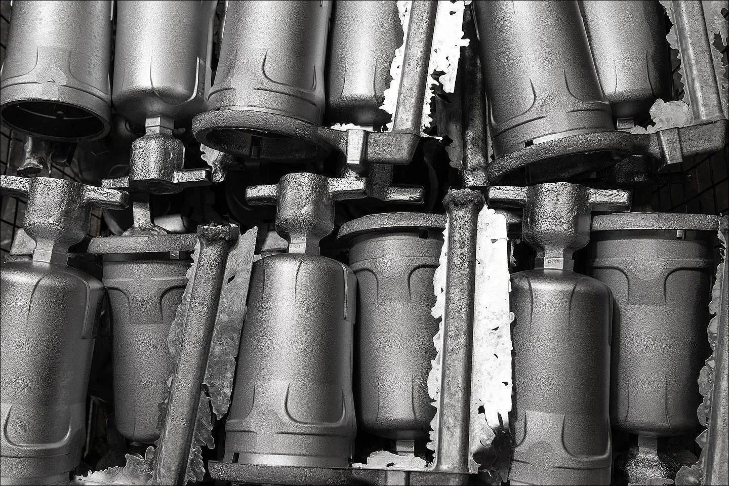 Black and white photograph of multiple industrial cylindrical components arranged in a grid.