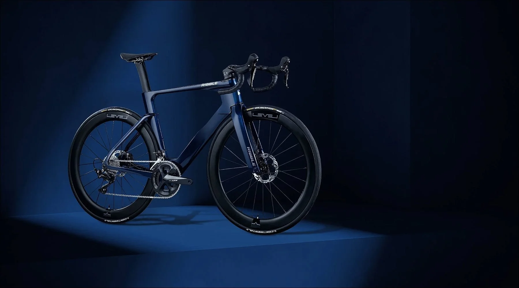Bicycle illuminated by blue light, positioned in a moody dark studio with geometric shapes.