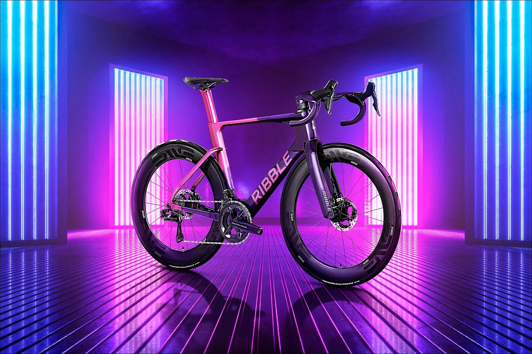 Bicycle illuminated by vibrant purple and blue neon lights on a reflective floor in a studio.