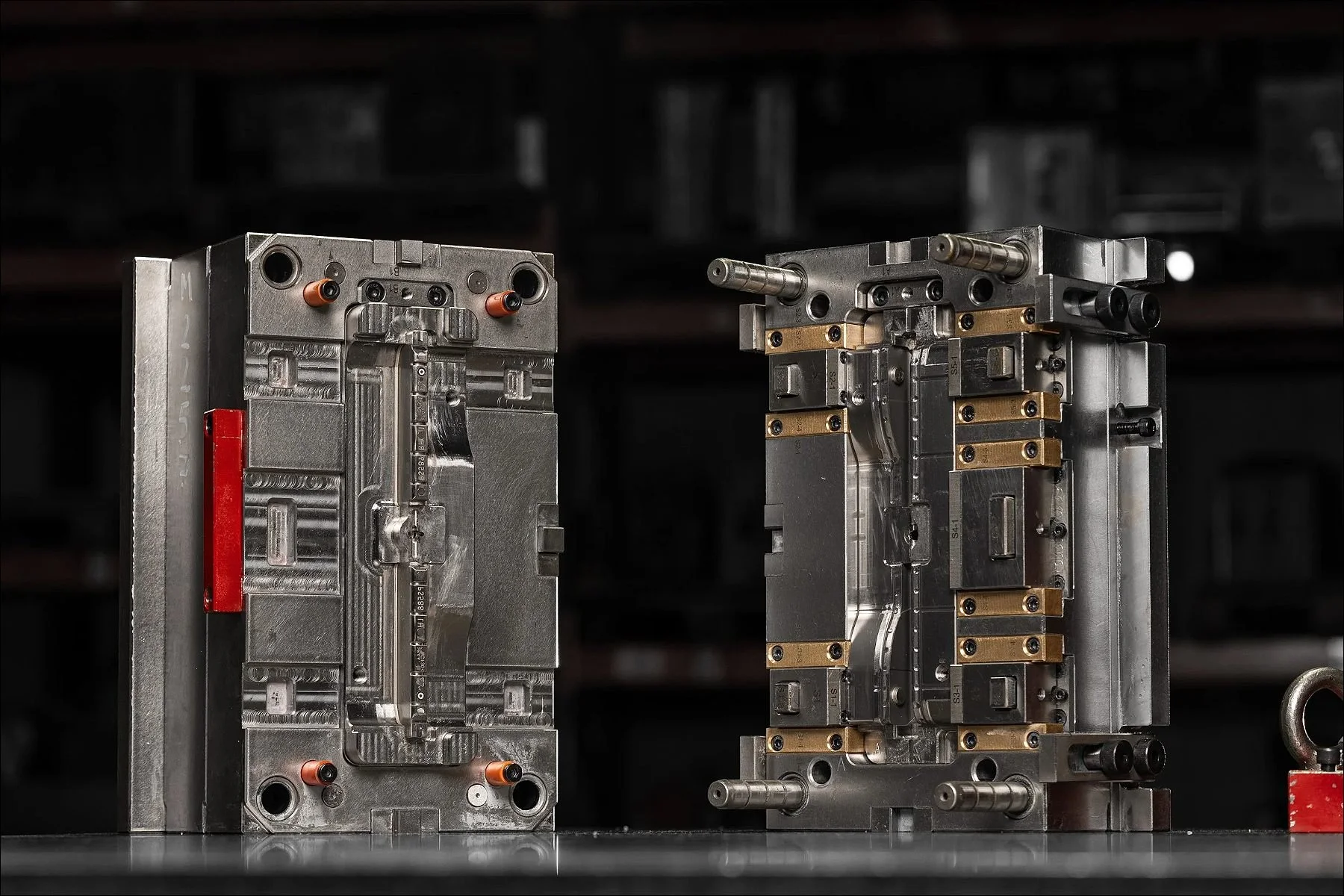 Two halves of an industrial mould or machine component displayed side by side against a dark background.