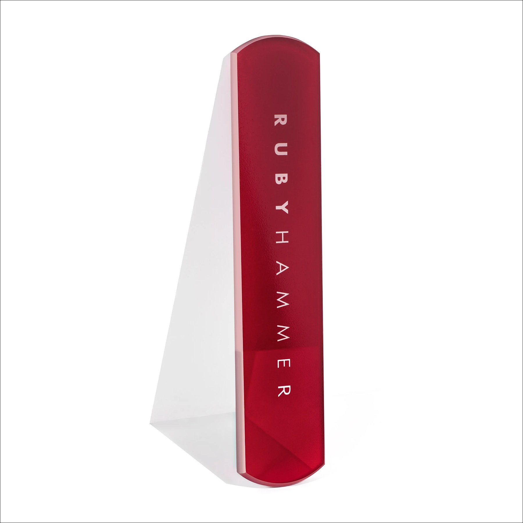 Tall red rectangular sculptural object with vertical markings, displayed on a white stand against a white background.
