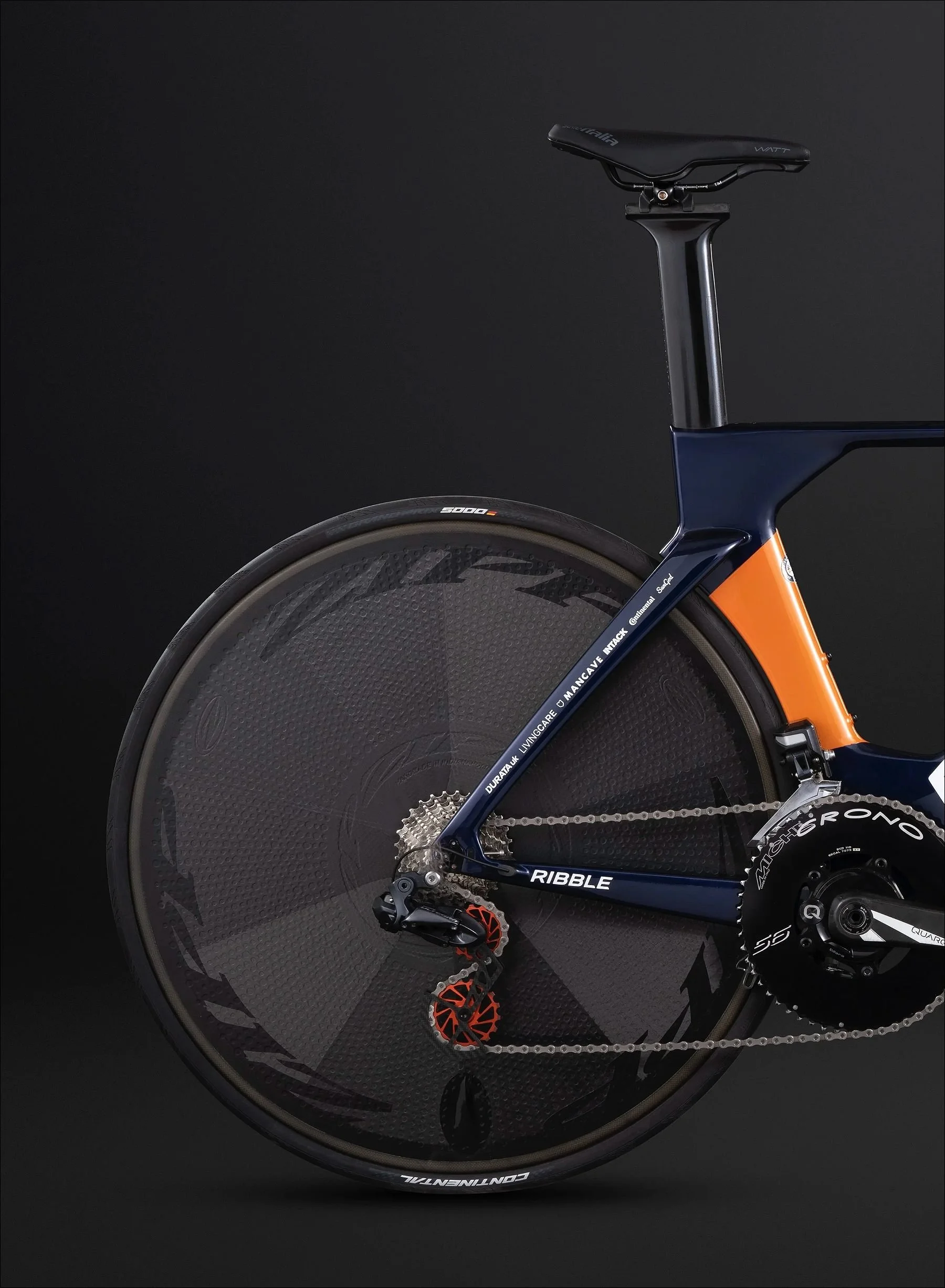 Time trial bicycle with disc rear wheel and orange accent on the down tube photographed in a dark studio.
