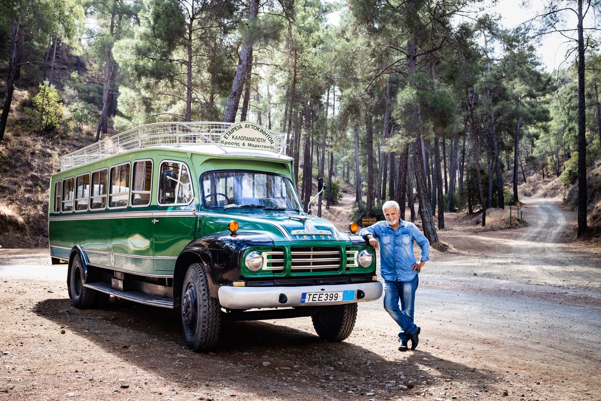 Man standing next to classic bus in the Troodos mountains, Cyprus.