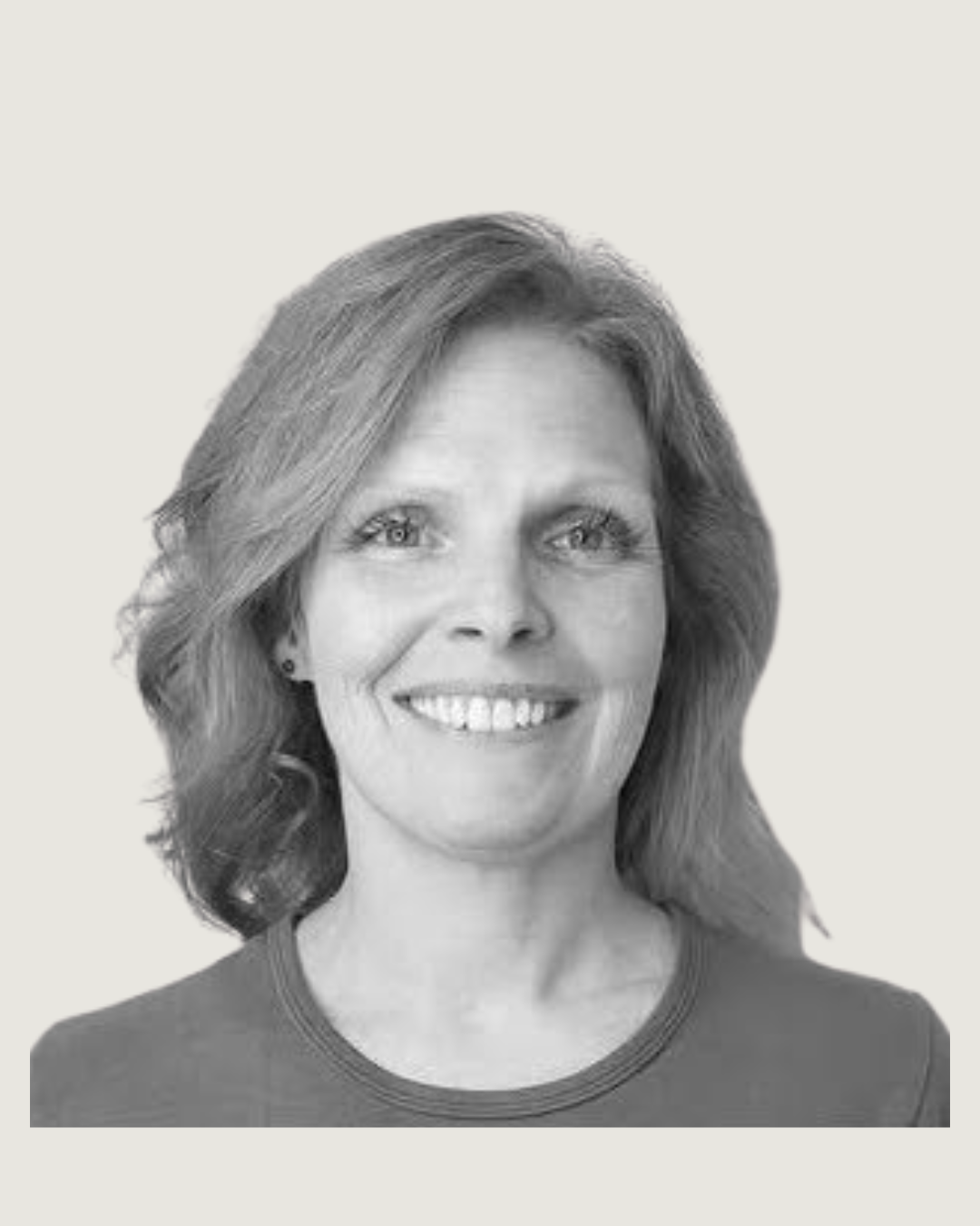 Black and white portrait of a smiling woman with shoulder-length wavy hair, wearing a round-neck top.