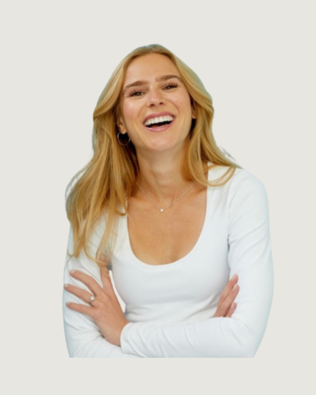 A woman with blonde hair smiling and crossing her arms against a light blue background.
