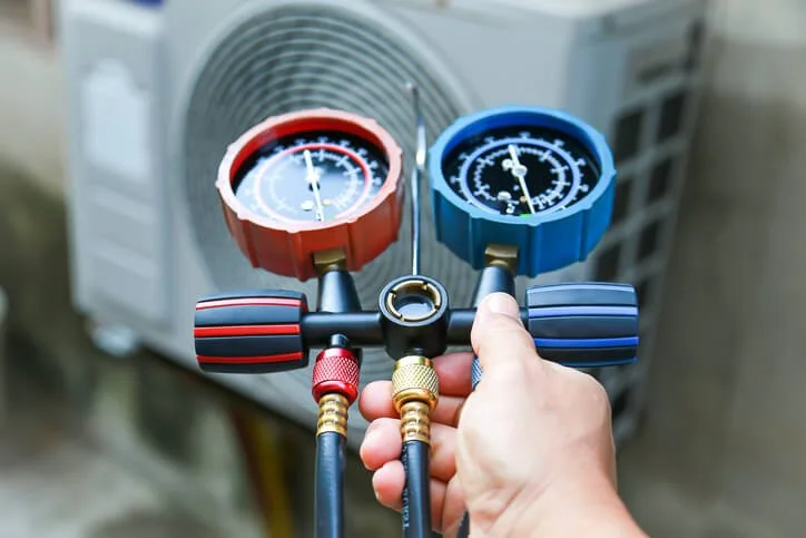 tech checking AC refrigerant levels