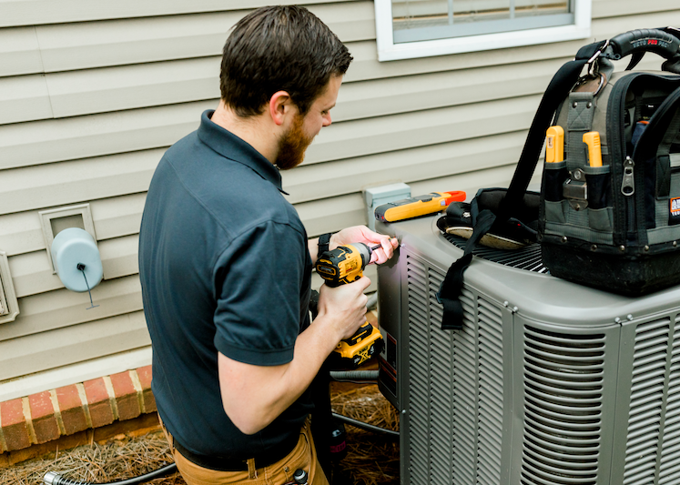 Tech servicing AC system