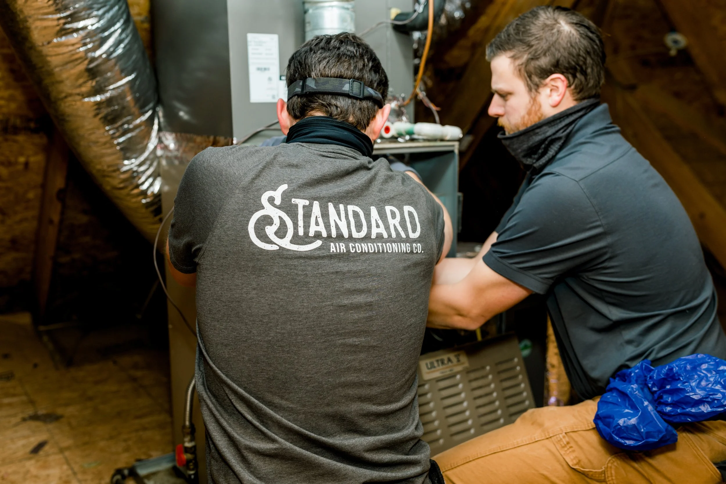 HVAC technicians working on a furnace.