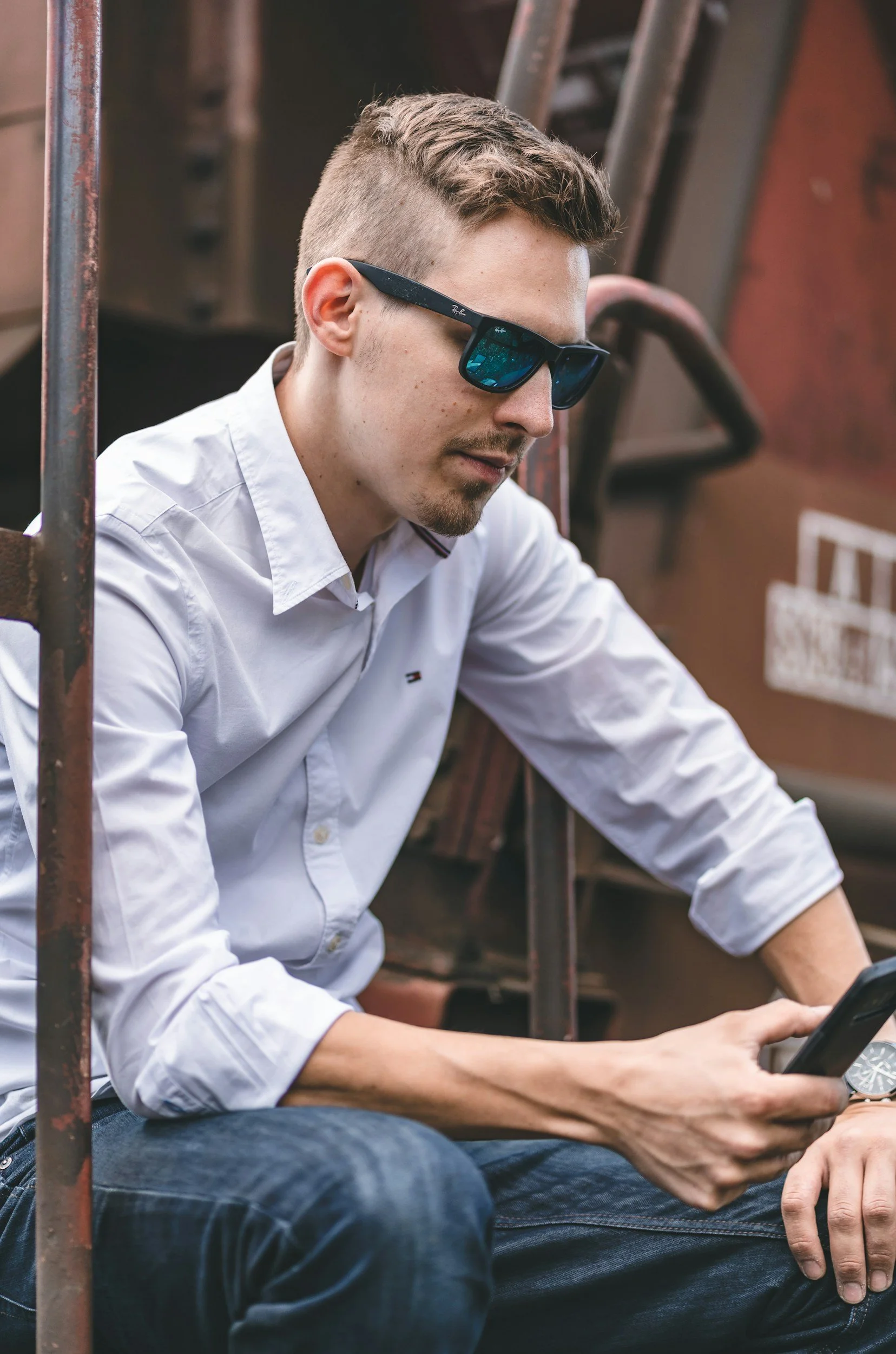 Man in sunglasses looking at his phone