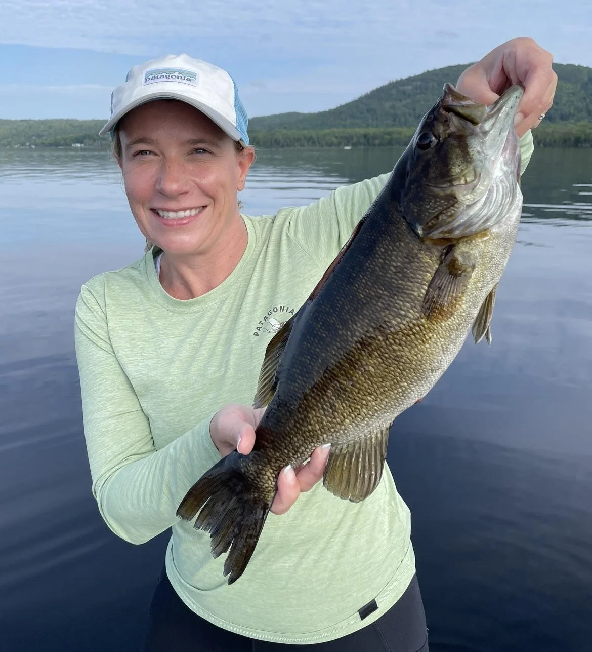 Person holding a fish on a lake