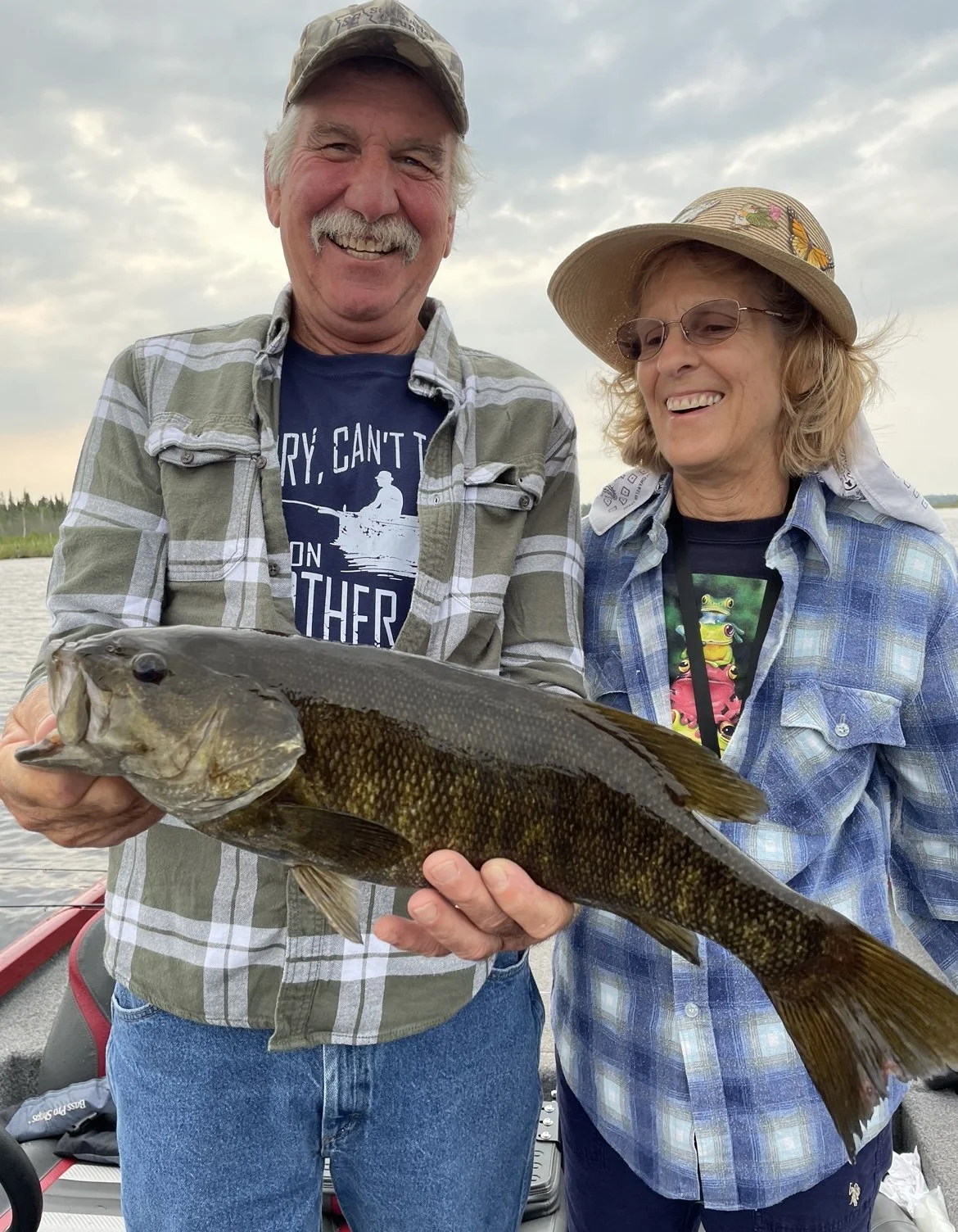 Bass Fishing Guide Services - Fishing Guide - Portage Lake, MI - Two people smiling while holding a fish, standing on a boat.