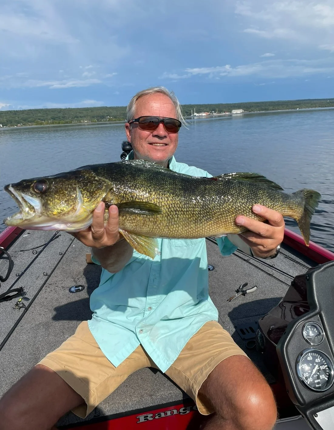 Man holding a large fish on a boat