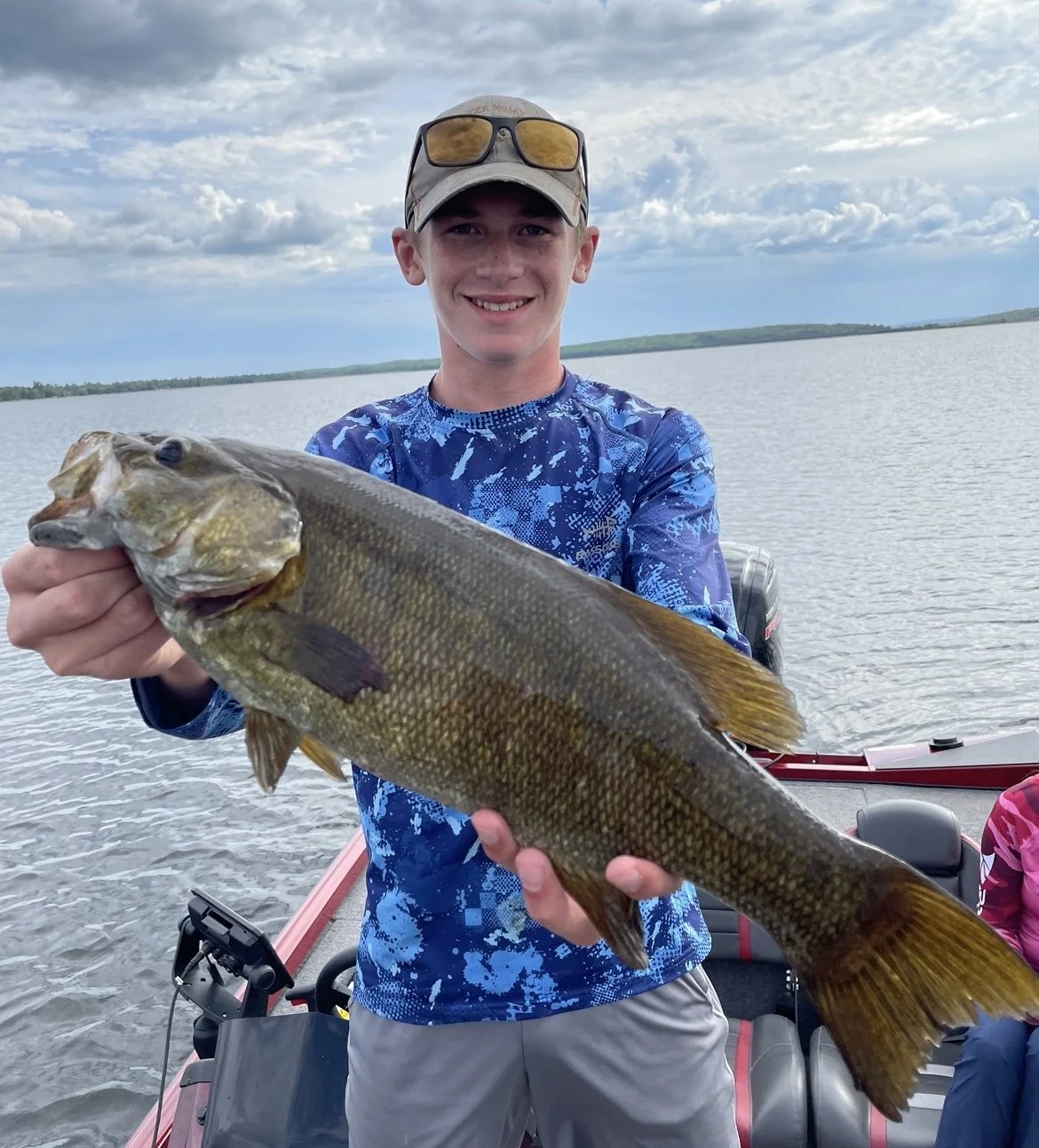 Person holding a large fish on a boat
