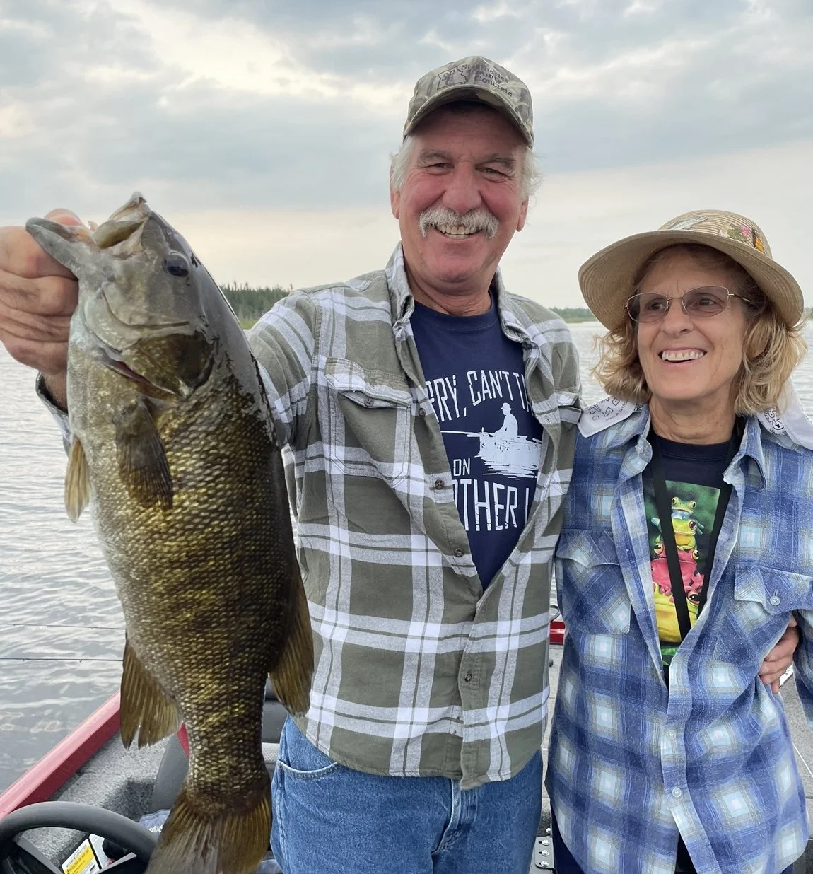 Bass Fishing Guide Services - Fishing Guide - Upper Michigan - Two people on a boat; man holding a large fish, woman smiling