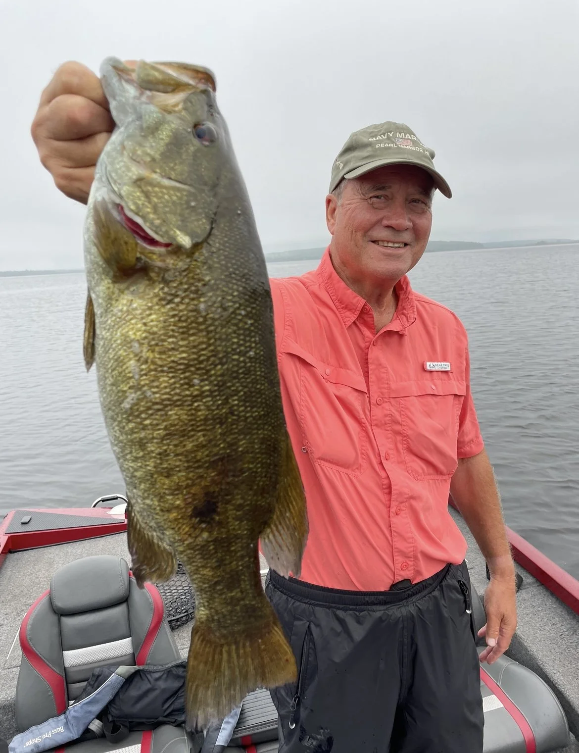 Bass Fishing Guide Services - Fishing Guide - Upper Michigan - Person holding a large fish on a boat.