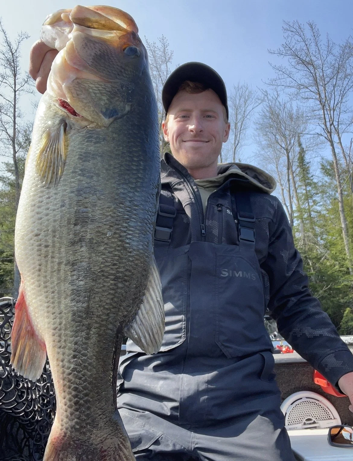 Man holding a large fish outdoors