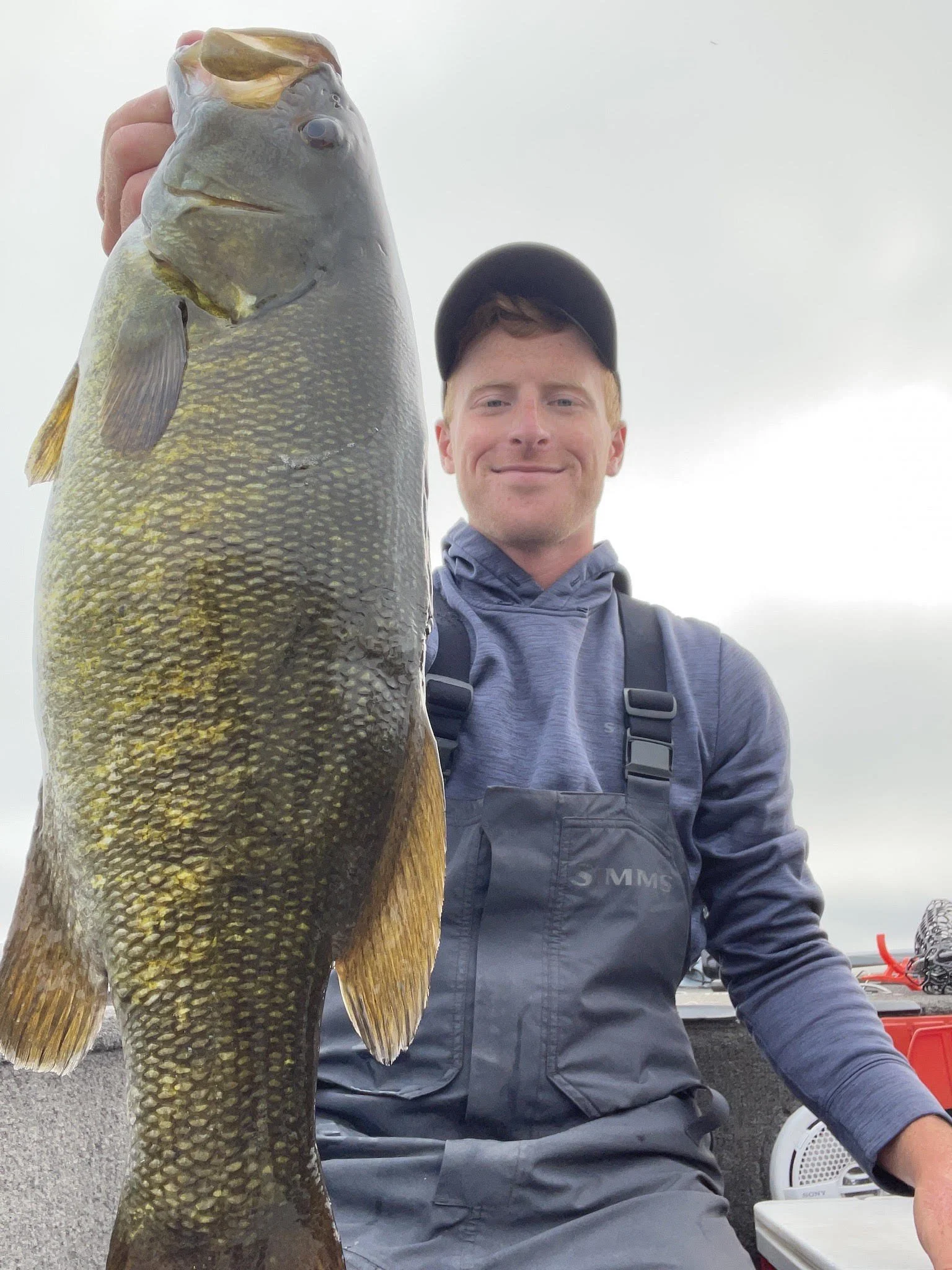 Man holding a large fish on a boat