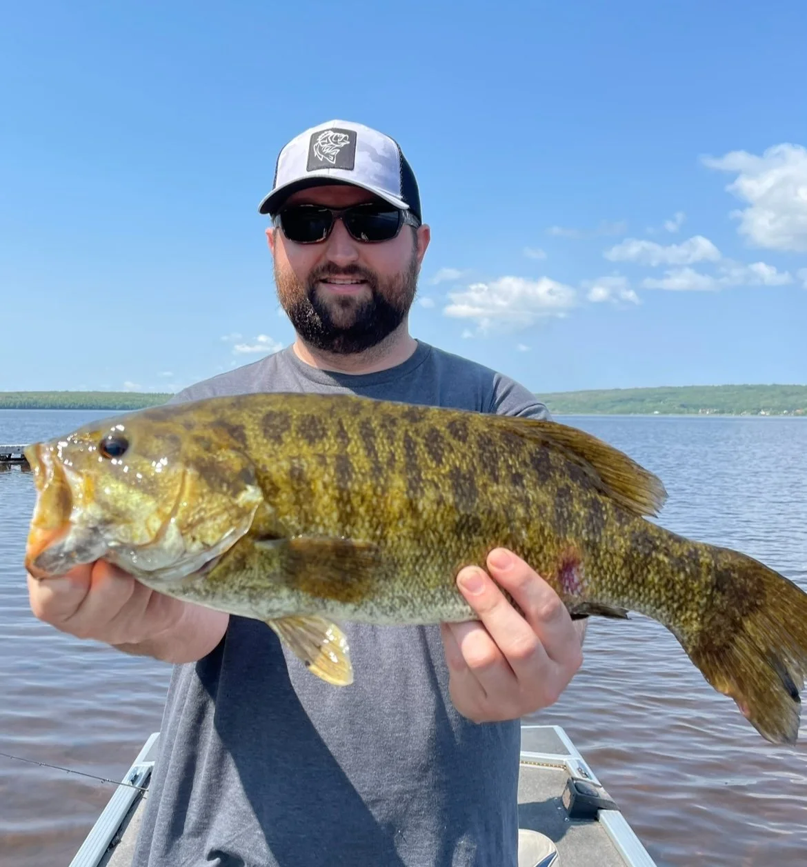 Bass Fishing Guide Services - Fishing Guide - Upper Michigan - Person wearing sunglasses and a cap holding a large fish