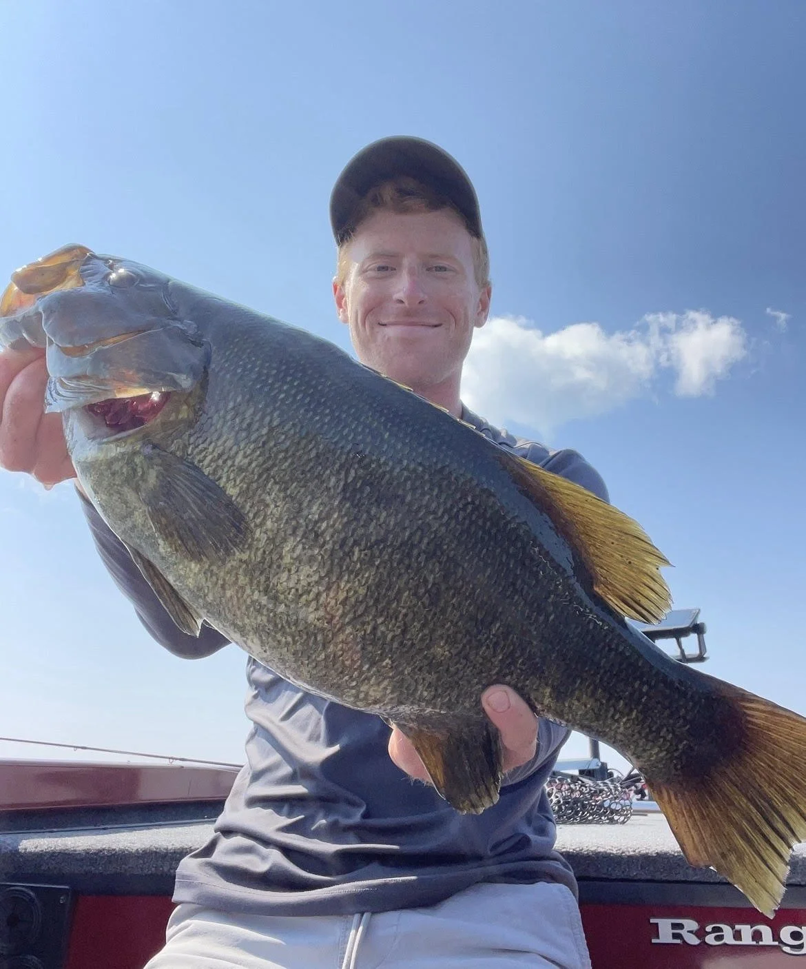Man holding a large fish on a boat