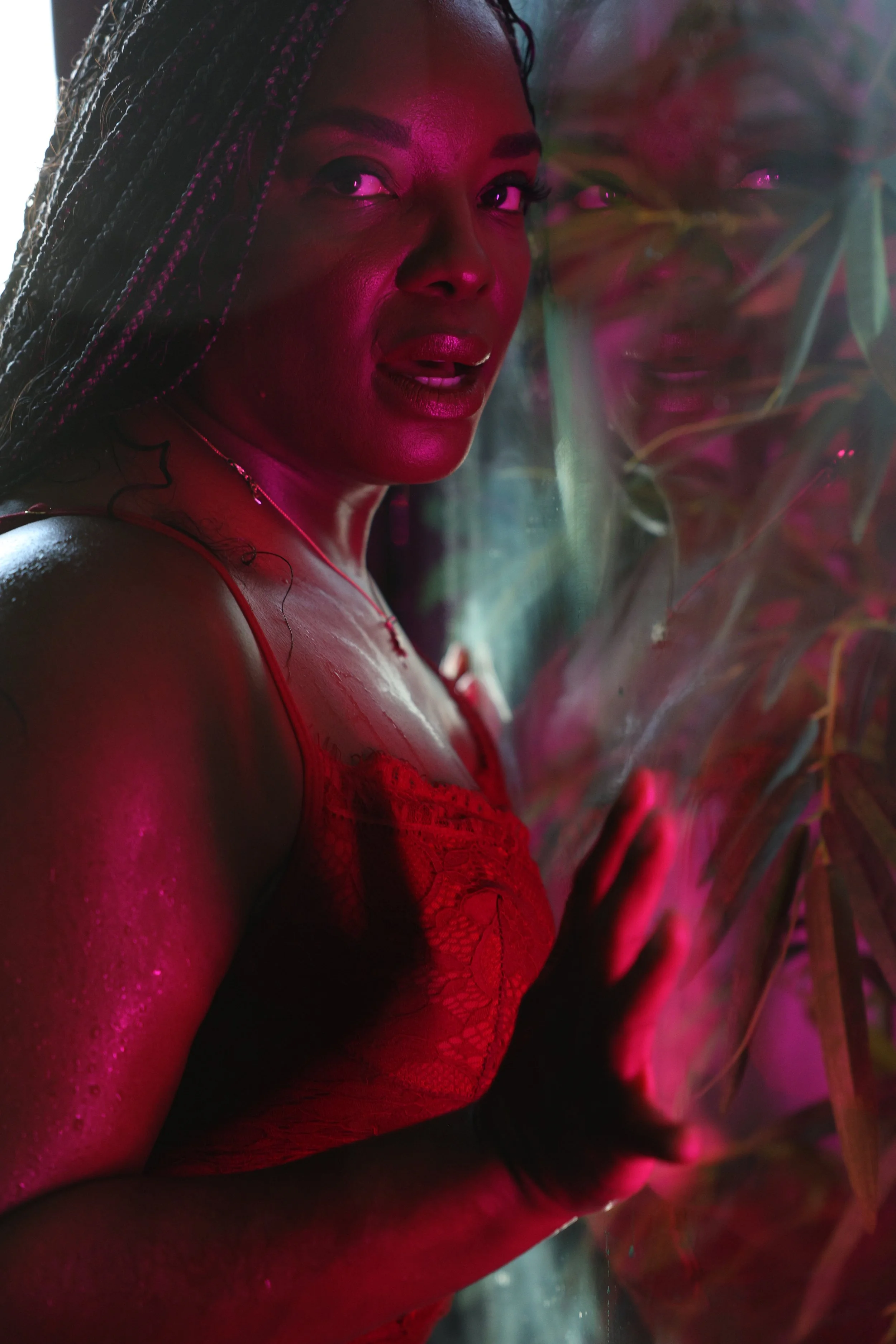 Intimate portrait of woman in lingerie with dramatic pink neon lighting and steam