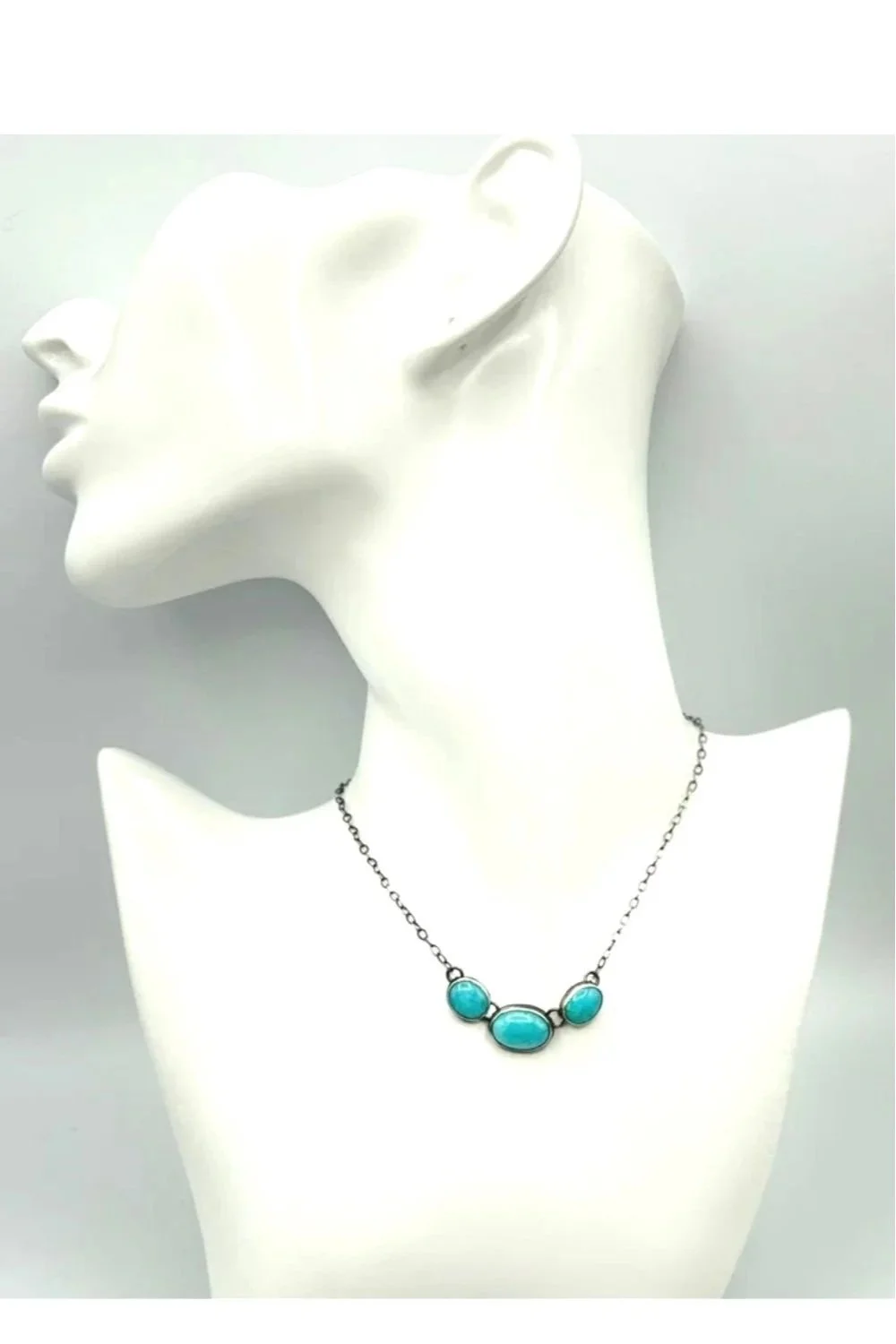 Necklace with three bezel-set Amazonite stones—one central oval and two smaller ovals—set in oxidized silver and attached to a fine link chain.