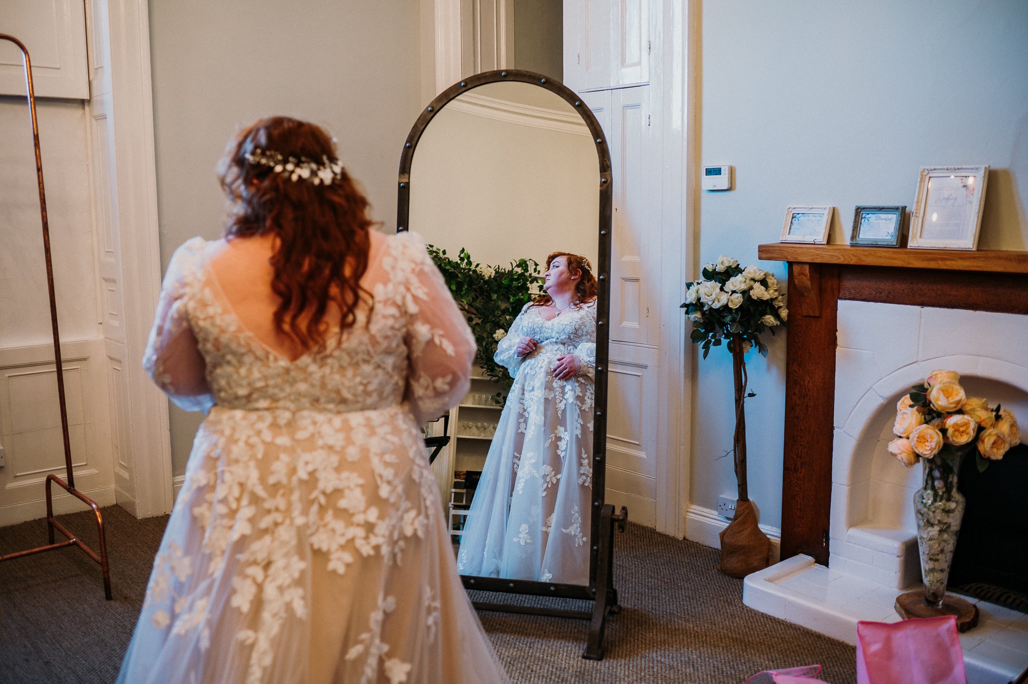 The bride checks her reflection in a mirror at Sneaton Castle, Whitby.