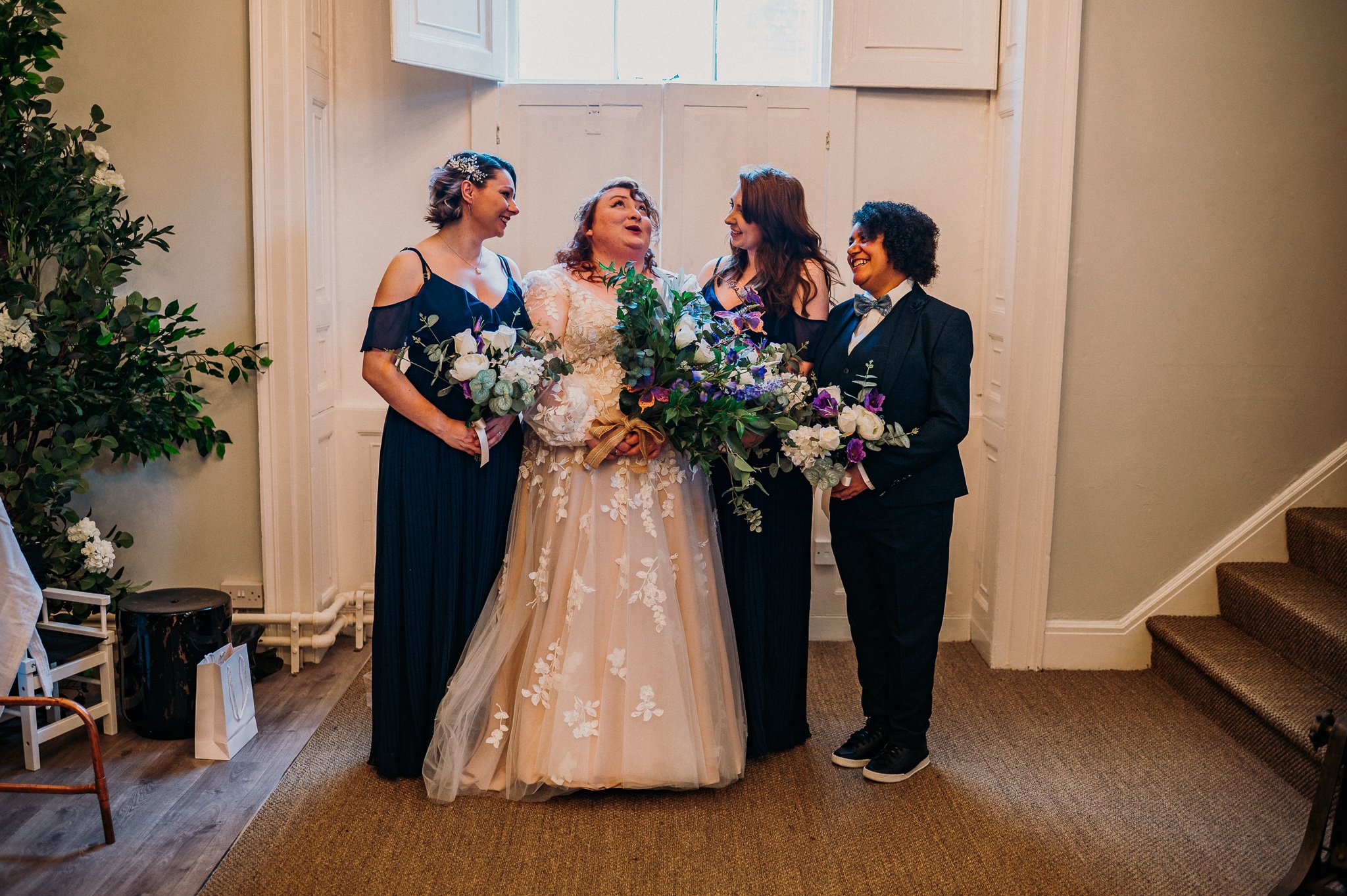 The bride and bridesmaids chatting a laughing about something in the preparation room at Sneaton Castle, Whitby.