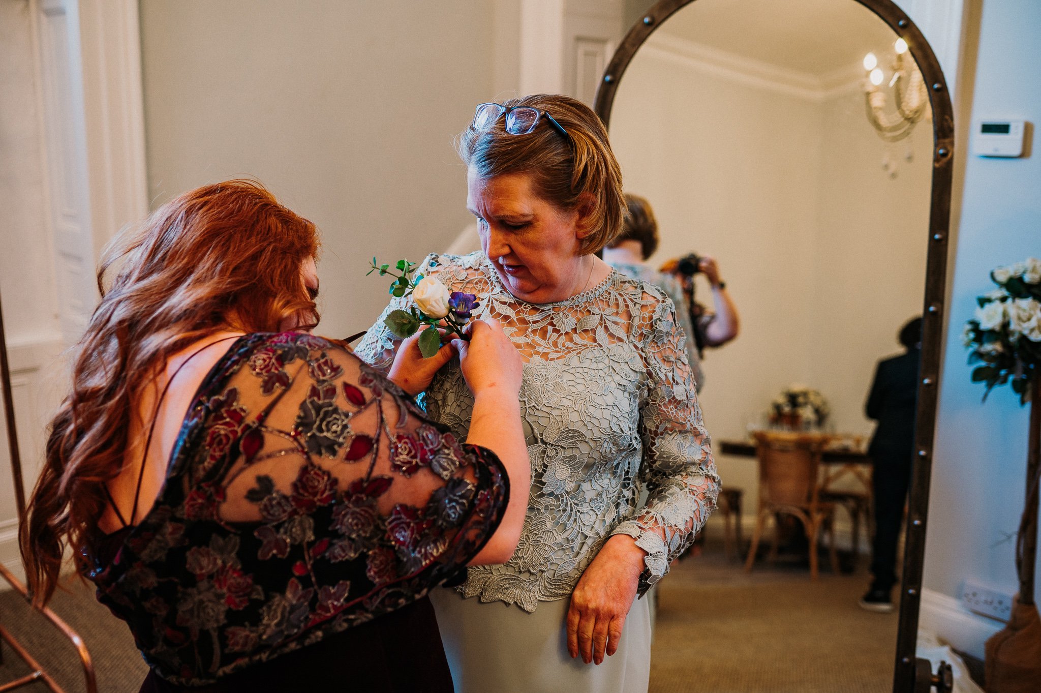 The mother of the bride getting her corsage pinned to her dress at Sneaton Castle, Whitby.