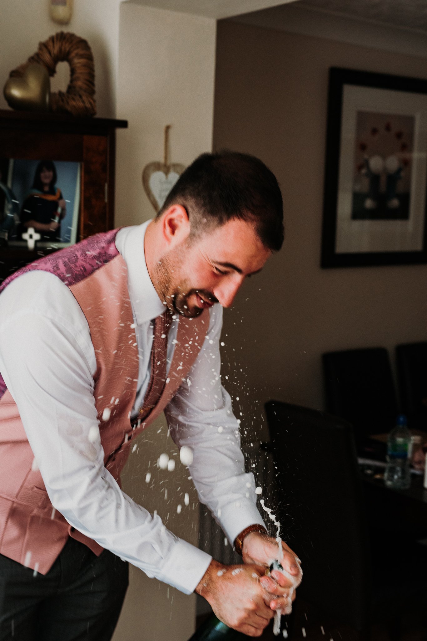 The groom makes a mess of his mum's kitchen when the champagne explodes as he pops the cork.
