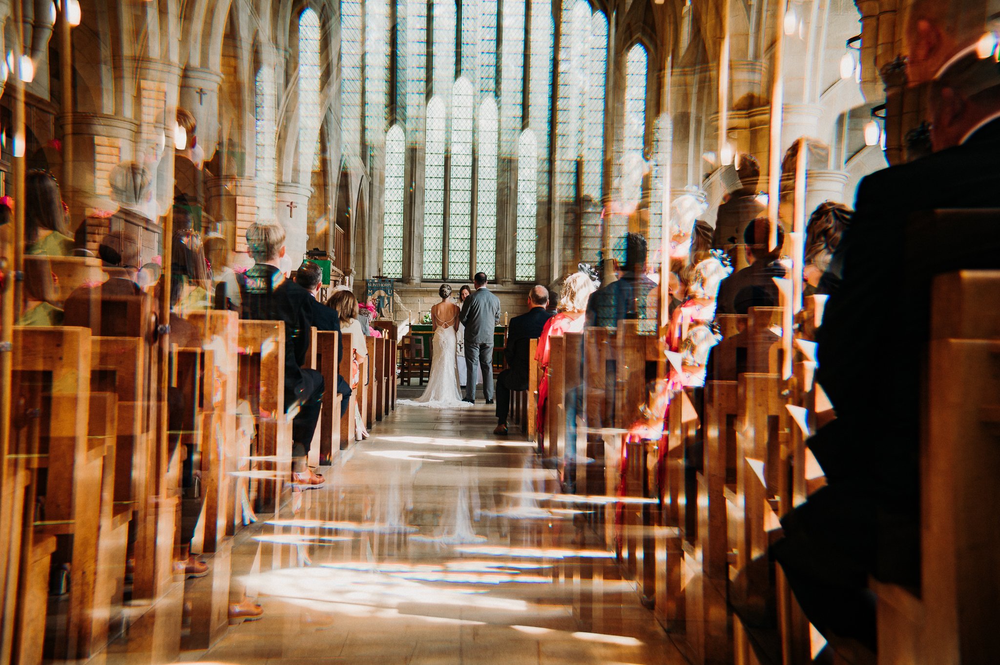 A creative, prism affected photograph of a bride and groom in their North East church on their wedding day.