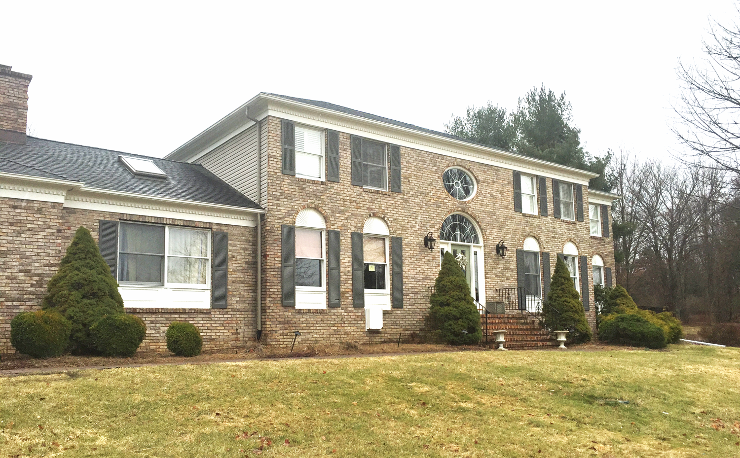 The brick front of this North Jersey home before renovation, featuring a standard exterior and minimal front porch entry area. The area is ready for a complete transformation with upgrades.