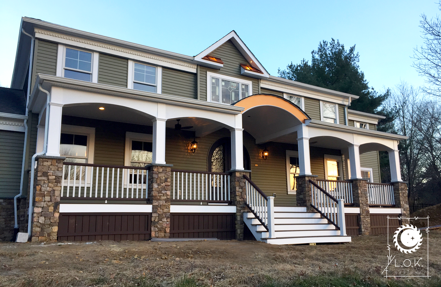 The dramatic transformation of this North Jersey home showcases a full exterior renovation. The custom stonework, expansive composite decking, elegant arches, and accent metal pieces enhance the front porch. Updated with custom exterior lighting and
