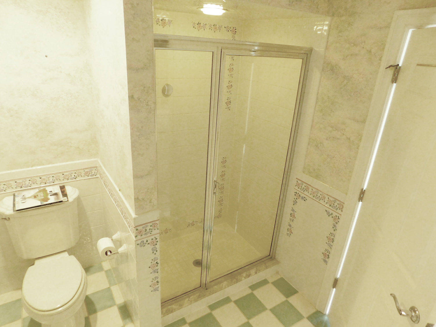 The Jack and Jill bathroom before renovation, featuring checkered blue and white floor tiles and a traditional layout. The space is primed for a modern update.