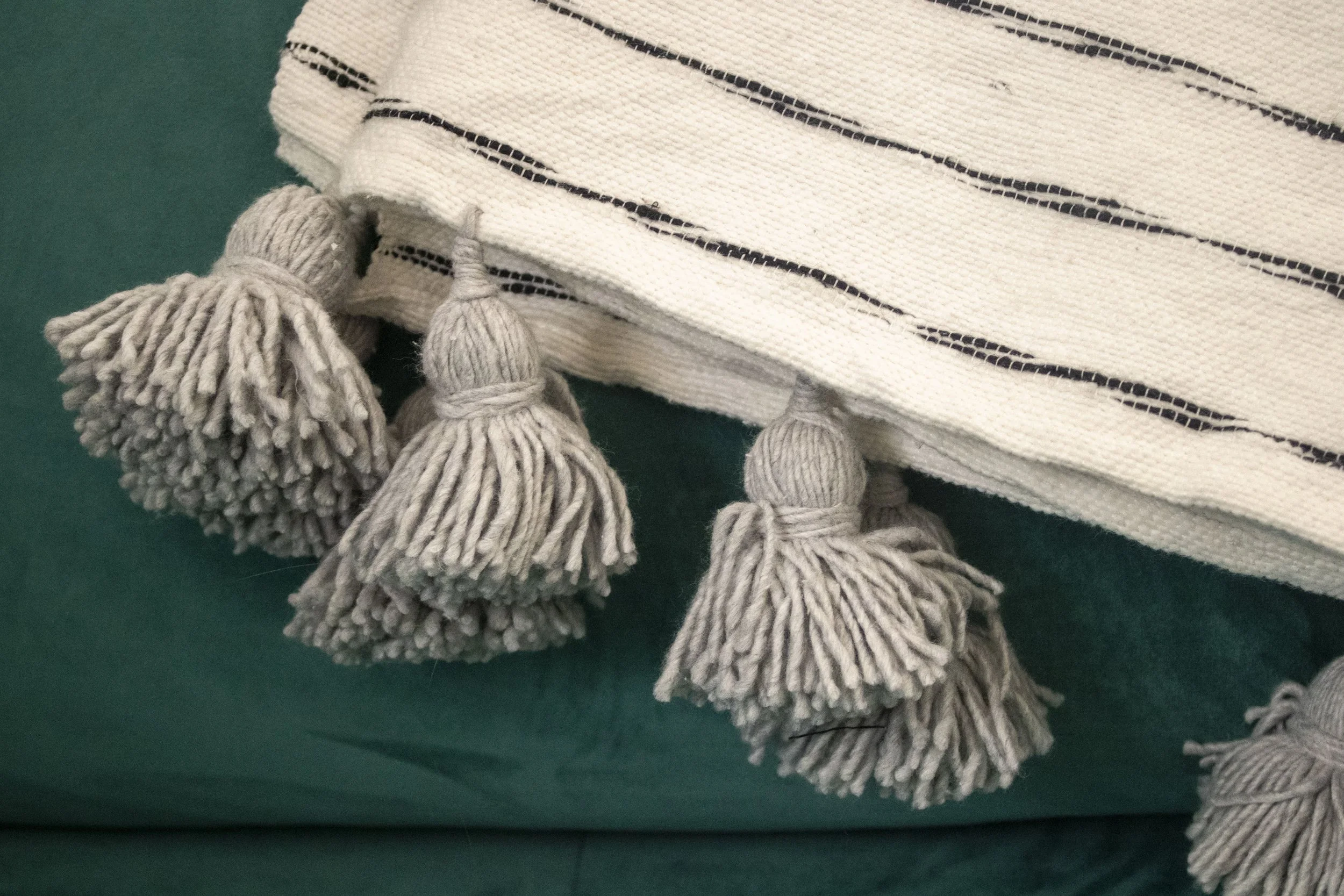 Moroccan.Wool.Blanket.Handmade.Striped.PomPom.white.Model.JPG