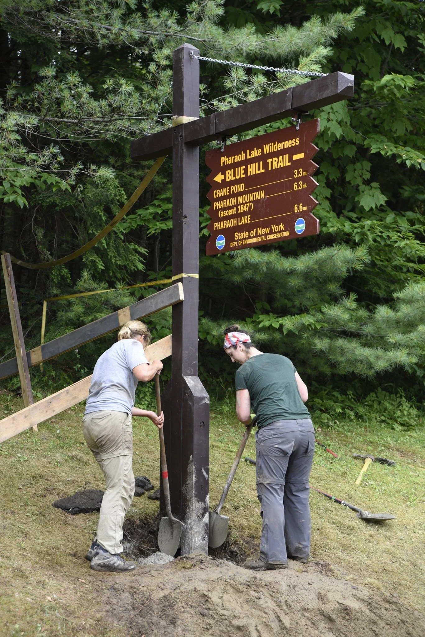 Two volunteer trailhead stewards installing a trailhead sign at the Pharaoh Lake Wilderness.