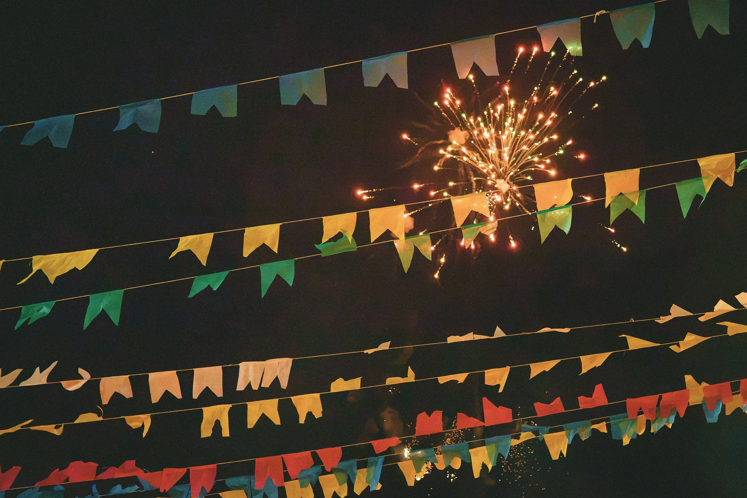 Fireworks and colorful flags at night in São Gonçalo do Rio das Pedras