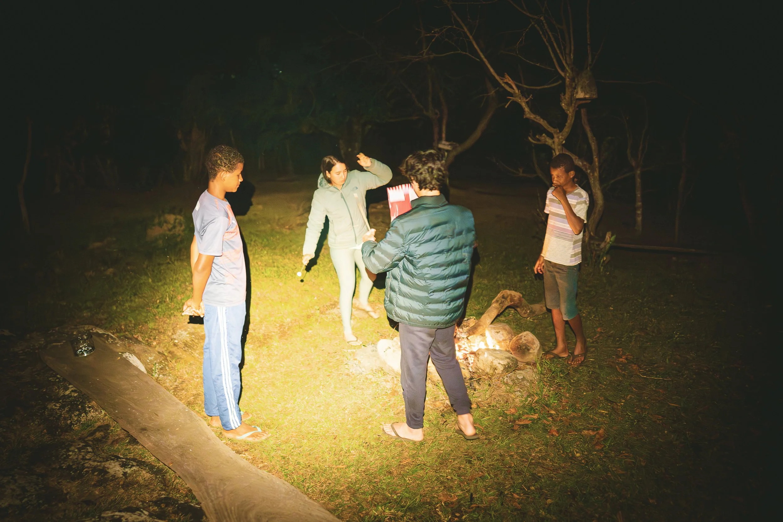 Dilsinho, Elisa, Tiago, and Diego around a small campfire in Quartel do Indaia, Serra do Espinhaço