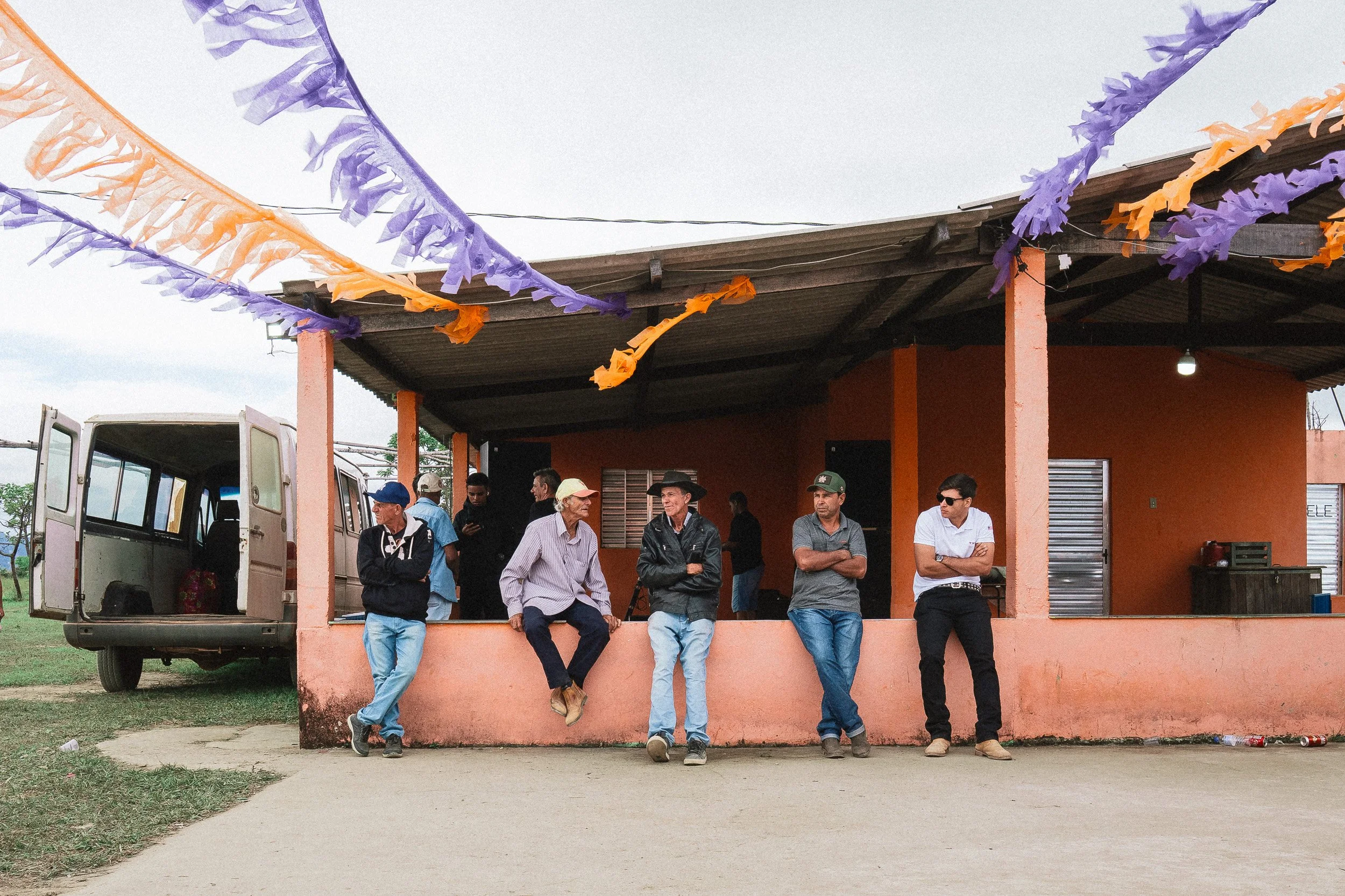 A group of men people-watch during a festival in Santa Rita, Serra do Espinhaço